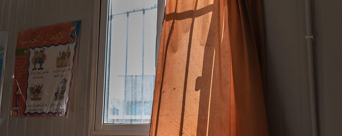 A curtain gently blowing in the wind from an open window.