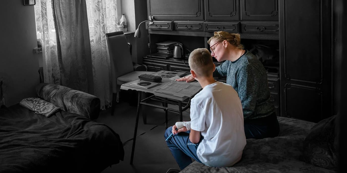 Mother and son doing homework in their living room. 