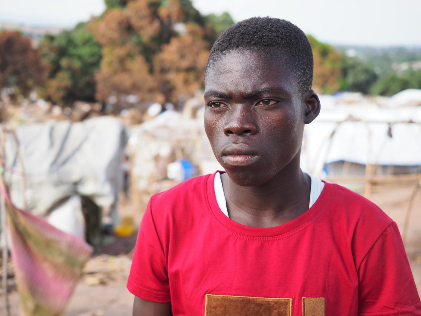 Masimango and Bone are brothers and they live together in an IDP camp in the Tanganyika Province. Masimango is 18 years old and fled for the first time in his life with his younger brother Bone who is 8 years old. They used to have a completely normal life back home in Nyunzu, but one afternoon two years ago, there was a clash between ethnical armed groups and they attacked the village. Masimango and Bone had done older sister and one older brother, but they both died during the attack. Their parents were killed as well. They still have some surviving relatives, but they fled to other villages so haven’t kept in touch. Masimango and Bone fled for hours until they reached a safe place where they were given a lift together with some other refugees from the village, with the train to Kaseke. 
 
The life in the IDP camp is very difficult. They are in a lack of food and they can only eat when they receive support and assistance from a NGO, or other people if they are lucky. They depend on support from humanitarian organisations like NRC. NRC has supported them with 50 USD so they received things they need in order to protect themselves and survive. They got a plastic sheet to protect their temporary shelter. If they don’t receive support from NGOs, the only option they would have is to beg. Masimango and Bone has some friends in the camp including an elderly person who support them and sometime provide the food and water.

Masimango is only 18-year-old, and he feels a big burden because he needs to be strong for his younger brother, despite the challenges they meet every day. He is very sad over the situation that they are suddenly in. It’s hard for him to be the only responsible person for his younger brother. The huge life change happened so quickly and they’ve made such a big impact on their lives. Being a displaced youth with no parents who can support them is extremely difficult. They hope for their future to be brighter.

Masimango wishes that he and Bone can go back to school. He had to drop out of school in 6th grade in primary school. Masimango would like to become an aid-worker so he can assist other people in need due to the on-going conflict. Masimango misses his family and his old life so much, but he tries to stay optimistic and says that as long as he gets food, he can stay strong and alive so he will eventually find a job. It’s all about surviving day-by-day.

 Photo: Ingrid Prestetun/NRC