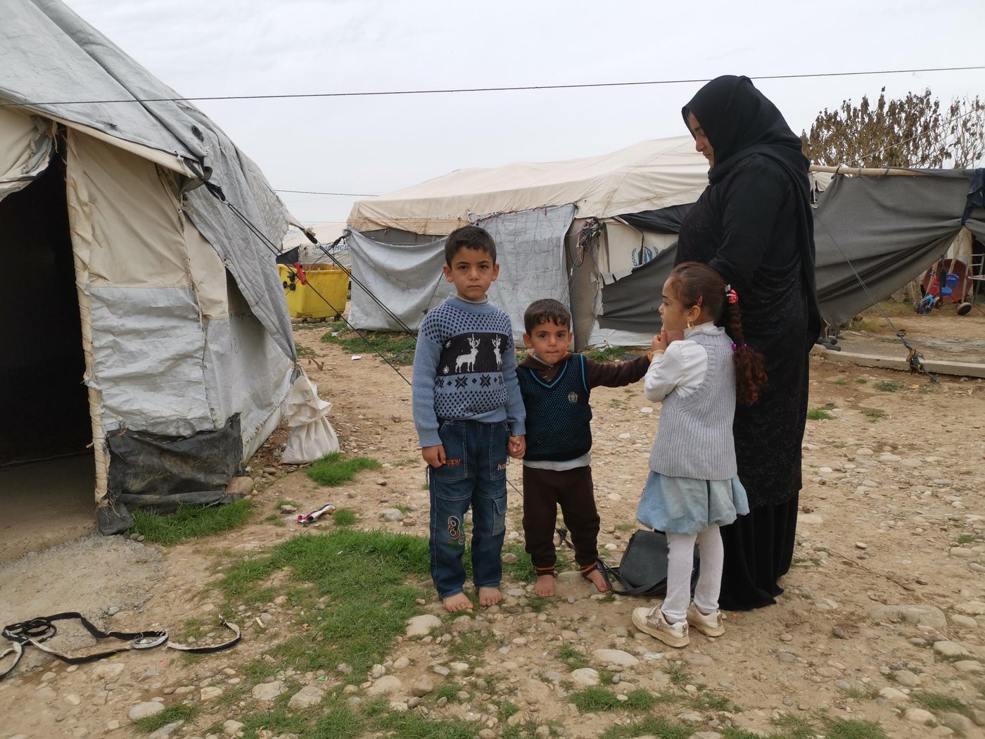 Rabiya – Displaced with seven children
“We have the papers proving that the house belongs to us. But when we fled we left everything in the house. We did not really think of house ownership documents. We only wanted to arrive somewhere safe,” says Rabiya, 47, a displaced mother of seven children from Hawija.
“As my husband is in prison accused of joining IS, no one from the government will help me to prove that the house belongs to us,” she says. She has been been living in a displaced camp since the war to retake Hawija in 2017.
Her husband and older child are in prison. She claims they are falsely accused having belonged to IS. Her husband was a shop keeper, selling products to everyone, including people who belonged to IS.
IS members cut her son’s hand because he was secretly selling cigarettes. He is currently in prison, jailed for 15 years with his father.
“Our relatives accused them of supporting IS and brought some fake witnesses to falsely accuse them,” she says.
Three of her children do not have IDs and others have the old versions, but they cannot get new ones issued because their father is in jail and accused of being an IS member.
“In order for me to issue a new card, I have to issue a tabrea paper first, which means I will be admitting that my husband belonged to IS. He is already sentenced to 15 years in jail. If I do that they will add 15 more years, or he will get a life sentence.”
Tabrea is a public announcement by the woman in question that she denounces her affiliated relative and the crimes he is accused of.
About returning home Rabiya says “I am tired of living in camps and being moved from one camp to another. I miss my house.”
Photo: Helen Baker/NRC