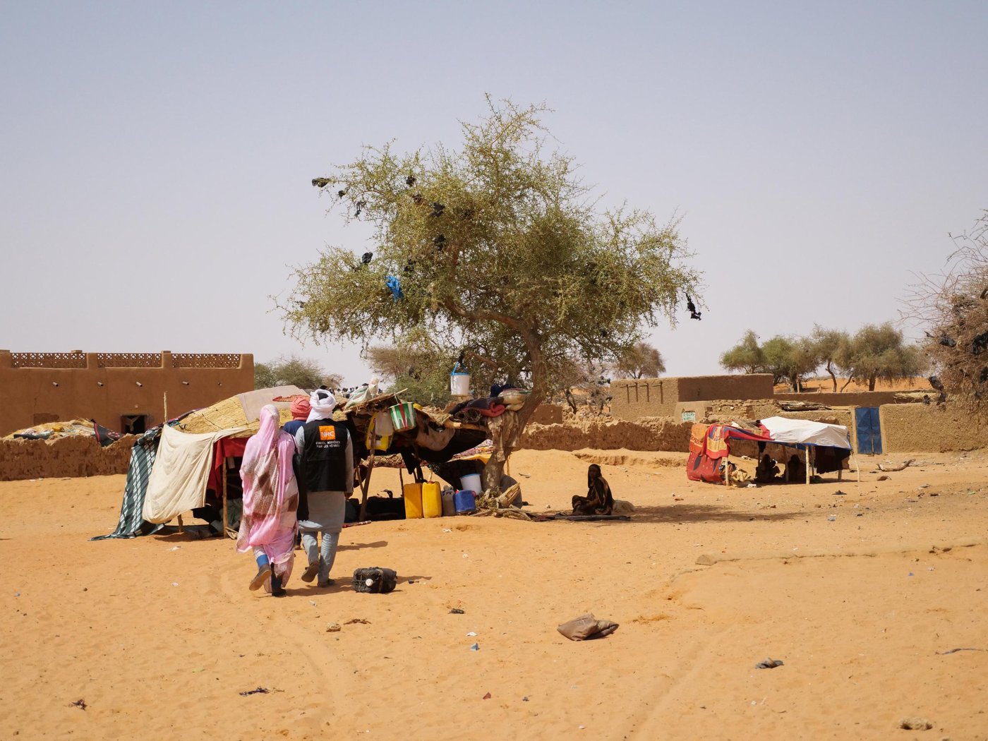 Two NRC staff walk through a makeshift displacement site in Ménaka, Mali.
Photo: Itunu Kuku/NRC
Date: Tuesday 11 May 2022
Location: Ménaka Mali