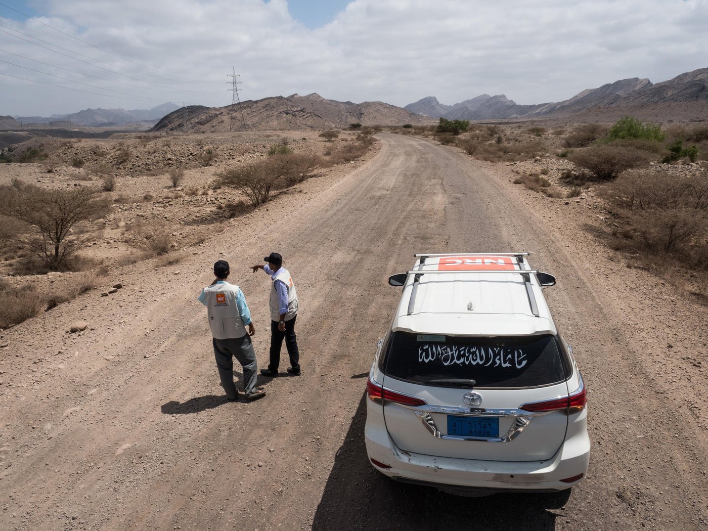 Aden, Yemen.
Landmines, airstrikes, lack of food and medical help, the list of threats in Yemen putting thousands of lives at risk is long. And delivering aid is no easy mission. When driving a car in Yemen’s conflict-affected areas, even the sky above you and the very ground you’re driving on are possible threats. Fastening your seatbelt is minor compared to the many other precautions that have to be taken. All of the Norwegian Refugee Council’s cars have a large NRC logo on the rooftop, clearly visible from the sky, to reduce the risk of being hit by airstrikes. Drivers must always keep to the main road, or, when off road, follow the tracks made by other vehicles.
The reason is simple: on a regular basis, cars and people are blown to pieces by landmines or unexploded bombs buried in the sand.
Yemen is described as "the forgotten war" and "the world's worst crisis", but for over a hundred of NRC’s employees, the country represents more than gloomy headlines. It’s their home country, where they were born and raised, went to school and where they now go to work every single day, providing their fellow Yemenis with cash, safe water, shelter and education. Photo: Ingrid Prestetun/NRC