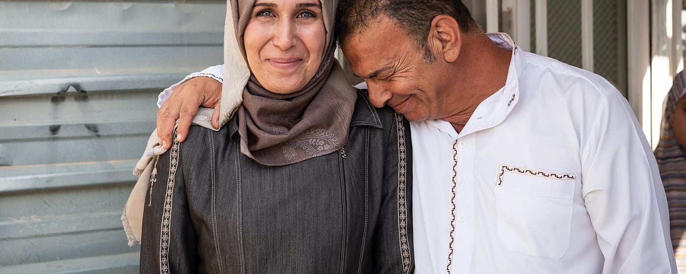 Husband and wife laughing.