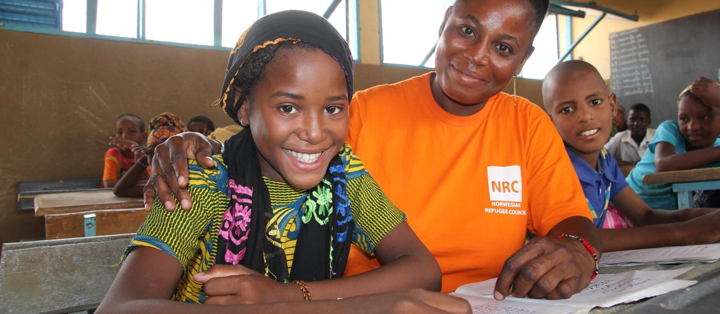 12 years old Sagda (green/blue dress, black head scarf) and reading is her favorite subject at school. When she grows up, she wants to be a doctor. 

Education:

NRC has through the years provided different types of education programs. In 2013-2015 NRC ran an education project in the Mentao refugee camp comprising a catch-up programme for children of school going age who have been forced to drop out of school. NRC also had  a YEP program (combining literacy educational and learning crafts) for youths between the ages of 15 to 24 who can no longer make in into the normal school system. 163 pupils completed the catch-up programme while 105 youths completed the YEP programme   

Now NRC is providing education for smaller children in the Goudebo camp; Ecole Primaire de Goudebo has between 800 and 900 pupils aged from 6 to 12 years, divided in six grades. The number of pupils differs with families trying to return to their country of origin. Return programme is facilitated by UNHCR.

Most of the pupils are refugees, but the school also has some pupils from the host community.

There are 6 grades at the school. In the first two years (CP 1 and CP 2), there are two teachers in each class. Because the school language is French, and many of the refugee children do only speak local Tuareg dialects, they need help for translation to be able to follow the education. (Official schools in Mali is also teaching in French)

NRC target that 50% of all pupils should be girls is met in the vast majority of the classrooms. The age of the children in each class differs. Most of the children arriving in the camp have never gone to school before, so they have to start in the basic class regardless of their age. 

Most of the pupils have books to write in, but in a few classes the pupils still uses small wooden boards and chalk. 

Photo: NRC/Ingrid Prestetun