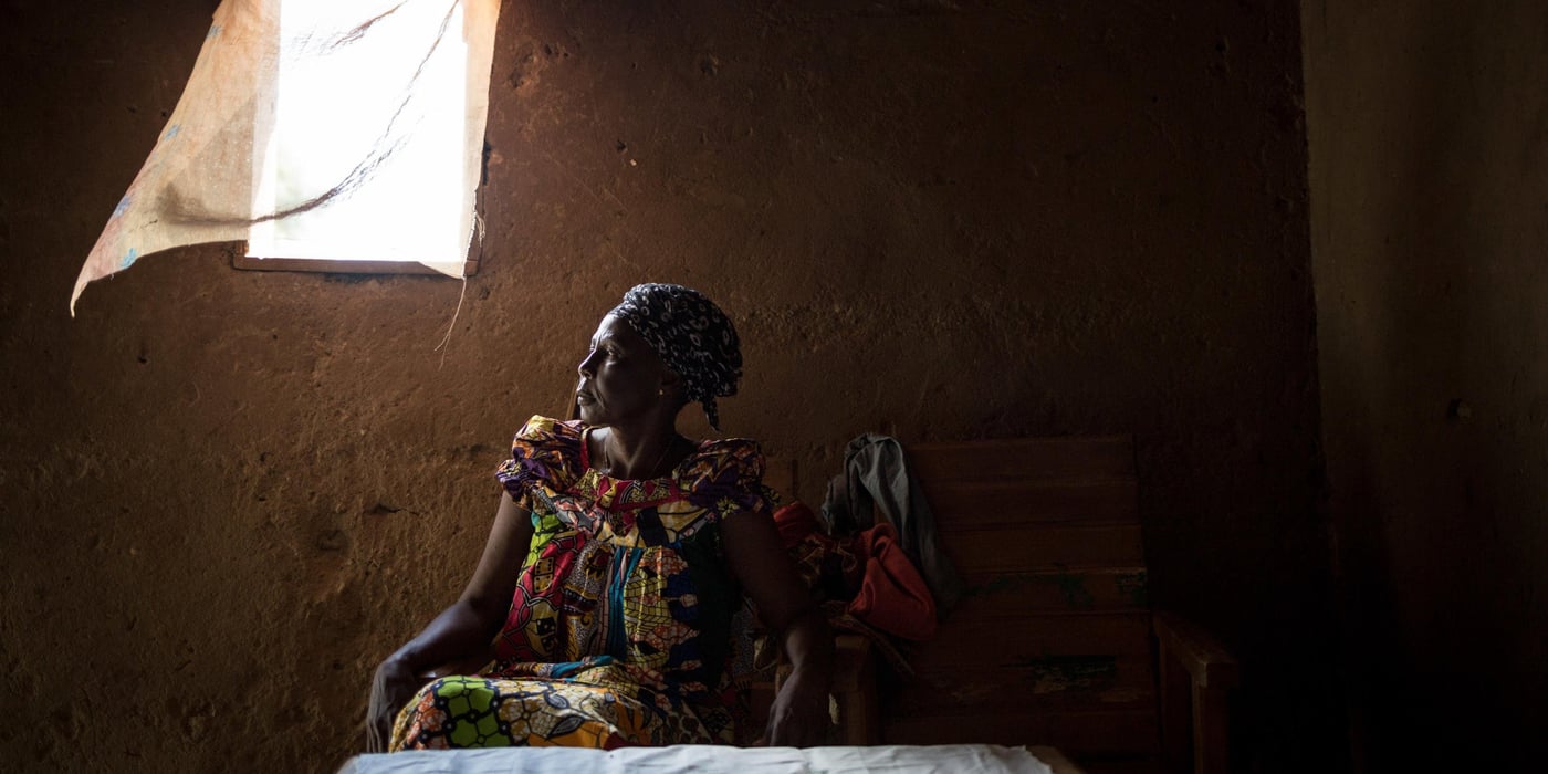 Marguerite Nguena poses in the house she occupies.
Marguerite Nguena, 62, widow, lives with some of her seven children and some of her grandchildren.
"On December 5, 2013, I fled to the Mpoko displaced site with my husband, children and grandchildren. A few months later my husband took a stray bullet at the site. It killed him. After that, we went to a cousin's house next door to the Combattants neighborhood. We lived a year like this for 14 people in the house. And then my cousin's wife chased us away."
"Then I came back to Bazanga. I live in the house of a Muslim who fled the neighborhood. He wants to put his house back on rent, but I can't afford to pay the rent. He gave me six months to find a solution. If I don't find a solution, I will have to go back to my native village in Bossembélé."
"I don't have a job. Sometimes members of my church give me something to help me. We are in a state of insecurity. Again tonight, around 9:00 p. m. we heard cracklings of weapons."
Since 2013, numerous outbreaks of community violence have provoked fighting in Bangui, the capital of the Central African Republic. In the most exposed neighbourhoods, the population was forced to flee to seek refuge with their families or in the various IDP sites of the city. Today all these sites have been closed and the inhabitants are returning home. The NRC meets these returnees to raise awareness of land rights and help them resolve conflicts related to illegal house occupations and evictions.
Photo credit: NRC/Alexis Huguet
Date: August 25, 2017