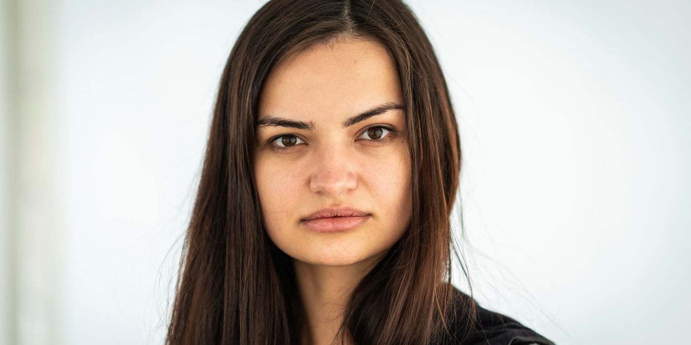 Portrait of a woman. She has long, brown hair and looks directly into the camera.