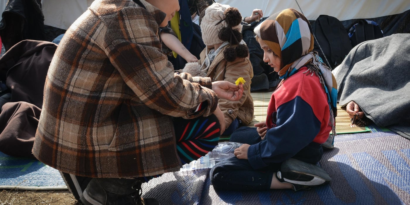 Shakiba (9) is giving a flower to Sara (4). They have both just arrived Chios, after fleeing from Afghanistan. In the background: Faribars (3).
Photo: Tiril Skarstein, NRC