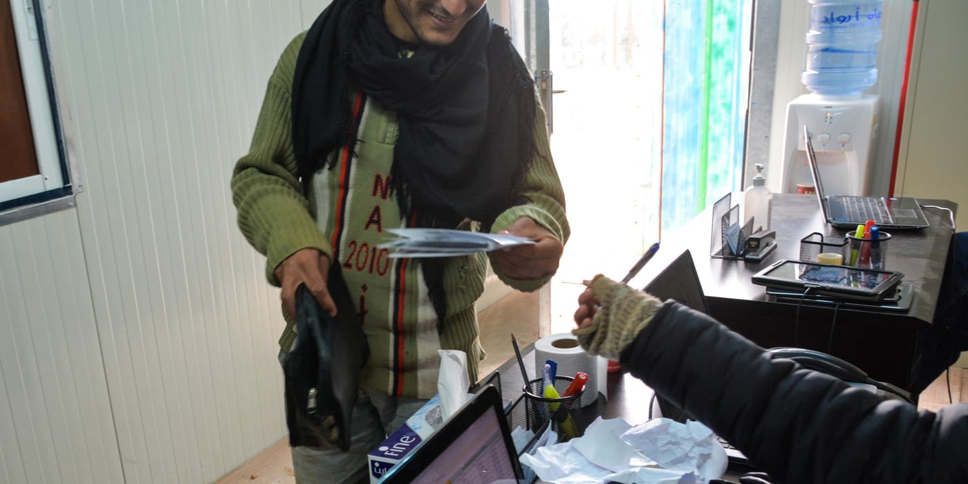 17 year old Omran is recieving winter vouchers from NRC's distribution compound at the children's booth in Zaatari refugee camp. NRC has a booth specifically for children who come on behalf of their parents to receive vouchers. January, 2015 Photo: Dara Al Masri/NRC Jordan