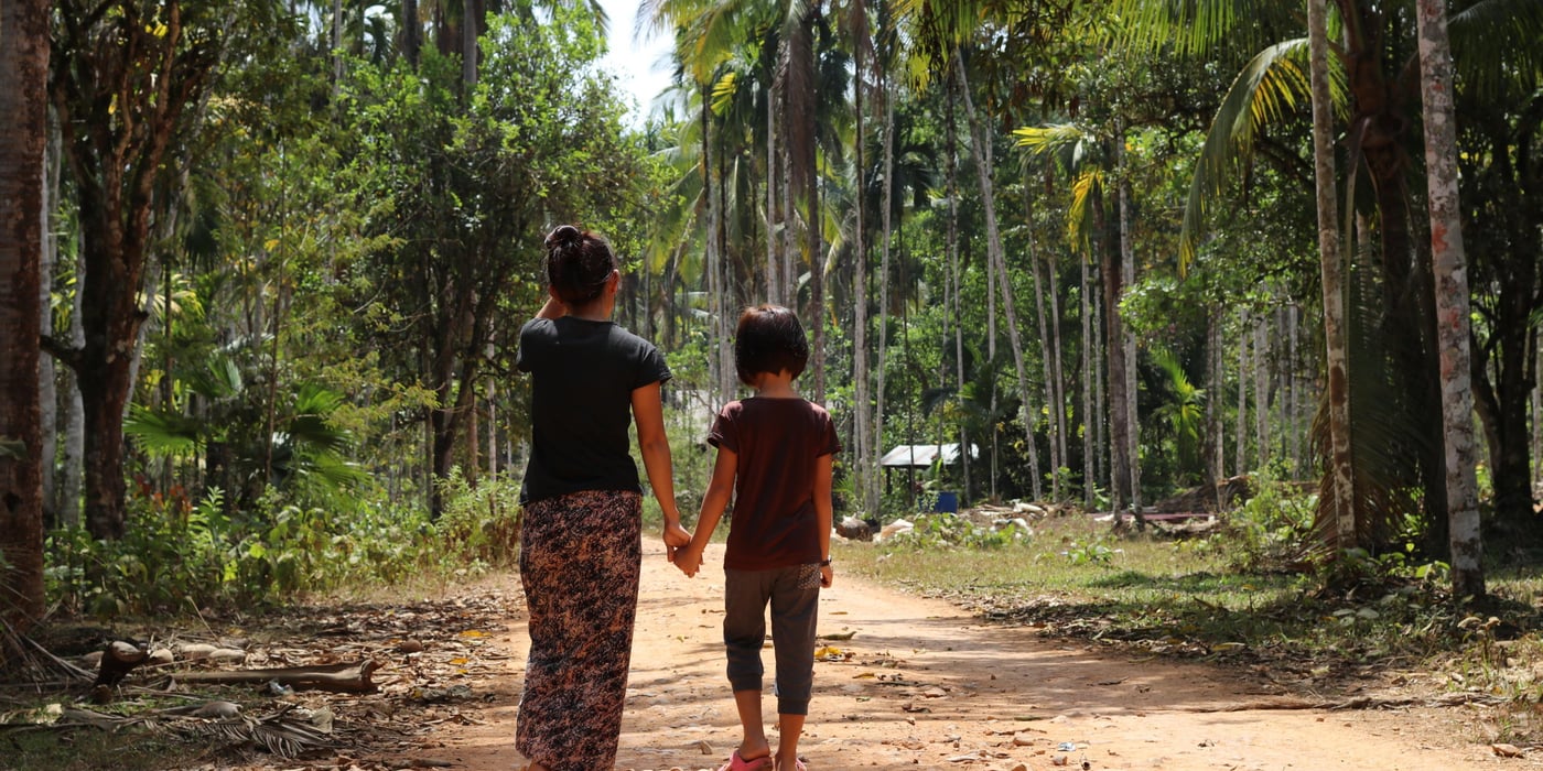 The first time she was forced to flee, Nyein, 32, was only 12 years old. That was 20 years ago, and only now is she returning to her home village to stay.
(The names of the mother and daughter are not their real names. The mother chose their fake names: Nyein means “peace” and Yone Lay means “rabbit”)
The whole village had to flee to the forests every time fighting between the government army and Karen National Liberation army (KNLA) drew close to their village. At the most, all the 60 families in the village had to hide in the forest for three months.
In the forest
“In the forest we were a big group, so we chose a group leader who would delegate everyone’s duties. The men went hunting for monkeys and the women picked vegetables,” said Nyein.
The fighting continued, and the villagers went back and forth between their home and the forest. In 2001, the fighting stopped, but the villagers did not feel safe and some of them continued going to the forest every now and then.
Forced to serve the army
The government army continued passing the village, and every time they passed by, they forced the head of every family to work for them for free, bringing them food or carrying their loads.
Nyein was the head of her family. During the fighting days, her father, the head of the village, was killed by the government army. They suspected him of sharing information with the KNLA. Her four older brothers were already married and her mother was old.
Nyein was forced to work for the same group that killed her father.
“I was very worried and felt suffocated,” she explained. She did not want to continue living like that.
Thailand
In 2005, Nyein made up her mind. Her father had passed away, her brothers were married and her mother could not afford her studies. She left her village and headed to Thailand.
She had heard that people made good wages there and she could also get the chance to go to school. Her mother let her leave on one condition, that she would not only work, but started studying in Thailand.
She arrived at a refugee camp in Thailand. For the first six months she was not able to find a job, and she stayed in the camp. Then, through a friend, she was employed as a nanny. Later, she had a job as a waiter for a while.
Three years passed without Nyein having any contact with her family. Her life in Thailand was work and study.
She worked for six months, studied English at night, then went to high school for four months during the day and then back to work for six months with English in the evenings.
In 2008, she met her husband, also a Burmese, but from another ethnic group.
After their now eight-year-old daughter was born, they continued living in the camp, working during daytime and tutoring the daughter in the evenings.
Home at last
Last summer, Nyein returned back to her home village. She brought her husband and their 8-year-old daughter, Yone Lay.
In Thailand, she could earn good money, but she was worried that her daughter would not get a citizenship in Thailand, and that she would have to work instead of going to school.
Also, rumours had it that the camp in Thailand was going to be relocated, which would mean that all those living in it would yet again have to move.
“I heard that the new government had signed a peace agreement with the Karen National Union (KNU), and trusted that it would be safe to return.”
She had missed her home village, especially at Christmas. The family returned to the village the spring of 2016 and her daughter started going to the local school.
Nyein has hopes for her daughter’s future:
“I want her to be well educated, have a good job, a citizenship in Myanmar.”
Since the family moved back, NRC has been I the village two times (In June 2016 and February 2017) to give ID-cards to those who does not have them. The parents, who already have the ID-cards, asked NRC whether their daughter would be eligible to have a ID-card as well, and NRC told them she would be when she reached the age of ten.
Today
Today, Nyein has opened a little shop in their house in the village, where she sells beetle nuts, a few grocery articles and medication. She took a basic medical course in the camp in Thailand, and is now giving the villagers medical advice and medicines. Those who come by to seek her advice often have no money, and as she cannot turn away a sick neighbour – her shop is not going very well.
Her husband works as a volunteer for a local NGO who is working to take care of the forest.
Future of Myanmar
“My father was killed because of the conflict and the suspicions between the warring parties. I wish for peace. I want freedom of movement and for the suspicion that has existed between groups and people for so many years to go away. I want people to trust each other and live together in harmony.”
“For now, we are just trying to make the best of things. Although I’m quite happy, I would wish for better conditions for my family.”
Her daughter just finished 2nd grade and is starting in 3rd grade in June, after the holiday (Summer holiday lasts from March to the end of May)
In January 2017, the new school in the village opened. The school was built thanks to NRC who financed the new building, and is providing school material such as school bags and notebooks.
“The old school was always covered in dust, it did not have good hygiene conditions,” said Nyein, “the new school has a white board, not a blackboard with charcoal.”
“Yone Lay loves to go to school, she loves writing and English. Her teacher says she is good in languages but not so good in maths.”
When I ask the daughter what she wants to become, she whispers in her mother’s ear that she wants to be a doctor.”
---
In Myanmar, the Norwegian Refugee Council (NRC) helps building schools in villages situated in remote areas and homes for local teachers, and we distribute school material such as school bags and note books.
In the southeast, we are working together with the authorities to give people information about the importance of civil documentation and distributing ID-cards to those who do not have it. With the ID-card, they have access to public services such as medical services and the possibility of opening a bank account, secondary education and they have freedom of movement.
Myanmar – the context
After fifty years of military rule, Myanmar welcomed a new era of democracy and reform with its first civilian elections in 2015. However, the newly formed government still faces the same issues as before.
Known as the “longest running civil war,” Myanmar has been tormented by internal conflicts led by ethnic groups struggling for representation since the country’s independence in 1948. Hundreds of thousands have been displaced in the decades-long conflict. Every day, people are being displaced by violence, leaving everything they own behind. Years of fighting have forced many to flee over and over again.
Since late 2011, the government has signed ceasefire deals with the majority of ethnic armed groups in the country, and in October 2015, the government negotiated a nationwide ceasefire agreement with eight of the largest ethnic armed groups. Still, some groups have refused to sign the agreement, and they continue negotiating with the government.
In addition to conflict, disasters and, increasingly climate change are forcing people in Myanmar to flee their homes.
In Myanmar, NRC helps displaced people and people affected by conflict through building disaster-resistant schools and wells, providing civil documentation, youth education and camp coordination. We have been working in the country since 2008 and all of our activities are managed from seven field offices within the Southeast Region, Kachin and Rakhine States.
We are working for people in Myanmar to have the right to education, work and property, so that they can live safe and independent lives.
Photo:NRC/Ingrid Prestetun