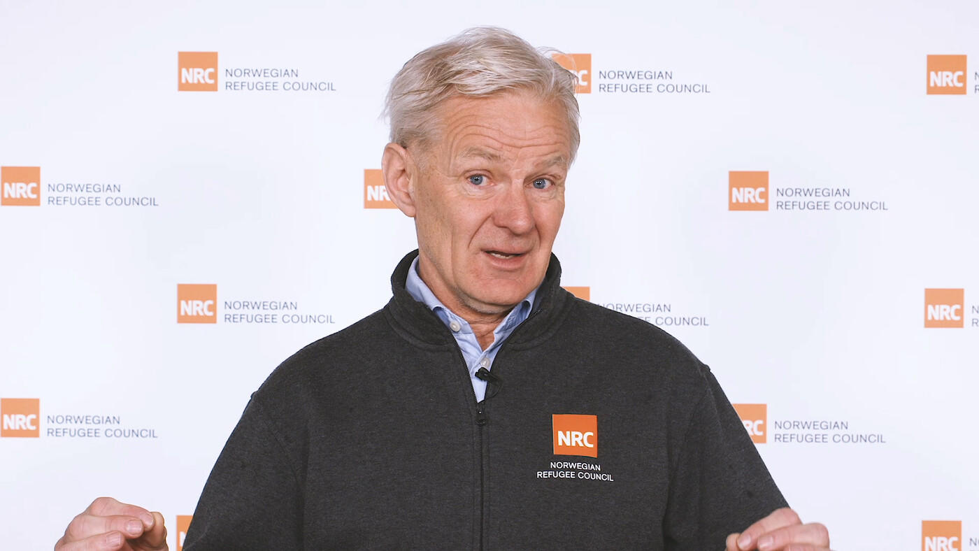Jan Egeland in front of an NRC photo wall