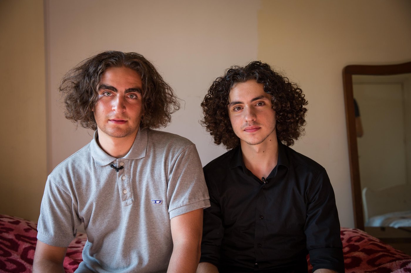 Marlon and Osama at home in the flat where Osama's parents and siblings live utside of Beirut.
When Osama was 15 years old he fled from the war in Syria together with his parents and four siblings. Now, five years later, he is 20 years old and has just seen his dreams for the future shattered yet another time.
Osama grew up in the outskirts of the Syrian capital, Damascus. A modern, vibrant and stable city until the war broke out in 2011. He lived a normal life. Went to school. “My country was a nice place to live in. I reached grade 10 in this school. I loved being there,” says Osama. “We lived in an area like Beirut. There were buildings and streets, it was not a village. Our flat was on the ground floor, with three rooms and two gardens. It's awful, because when I was a child, I had a dream to build my future life in that area. I wanted to become a doctor, and open a clinic in my house. My father and mother used to tell us, my siblings and I, that we will transform the house into a medical centre, each room for each one of you. But we cannot do it now. So, I should find alternative solutions, alternative dreams.”
“Maybe you heard about the chemical attacks in 2013? We were near the spot where the chemical attacks happened. After the attacks, president Obama said that he will attack Syria or some points in Syria, so we left. We decided to leave Syria for 3 months, we hoped that the condition in our country would become safer. But the conditions stayed the same, not stable.”
“Maybe I should start with the positive things. I am a student in the university. I got a scholarship here. My family is with me. I am sure this is a good thing. My friends' families stayed in Syria.” The dream of becoming a doctor and open a clinic is put on hold for Osama. “Now, I am a computer science student, maybe I will find myself there. I hope I can open a mobile school to teach people.” To be closer to university, Osama lives in a shared flat with nine other Syrian youths in central Beirut. They are close knit group who support each other through thick and thin. His family rents an apartment outside Beirut, and Osama spends his weekends there with them.
For a Syrian refugee living in Lebanon, there are many limitations. Osama and his older sister are the breadwinners of the family and feel the big burden on their young shoulders. “Even if you found an opportunity to complete your education, and you have a master degree or a PHD for example to become a doctor, you are not allowed to work. Living here is very expensive, so you need a lot of money. My biggest challenge is that the economic situation is so bad, not for me, but for all the Syrian families.”, says Osama.
“Maybe the bad things here, as a Syrian guy in Lebanon, there are a lot of regulations that restrict my life, which make me not like a normal guy. Right now, I don’t have an official residency, so I cannot go to every place I want. I entered Lebanon legally, but you have to pay $200 per year for each person above 15 years old for a residency permit. So, if your family consists of seven members like ours, you have to pay $1000 yearly. I didn't pay, so they took my passport and now I cannot move or leave this country.”
Osama and his family have tried to find another way to build their future elsewhere. They applied for resettlement. After a long process, including two interviews, Osama got the phone call. They were rejected. “I feel I am in a big jail. Like an animal in a zoo,” says Osama with tears in his eyes. The rejection was a big blow for Osama and his dreams for the future for himself and his family. “I cannot go back to Syria, and I cannot leave this country. So, I will try to live here.” Osama tries to think positive. “I consider Lebanon my second country, I love Lebanon so I want to serve this country. I want to build my family here. When I came here they said welcome, so I owe them one.”
Photo: Ingebjørg Kårstad/NRC.