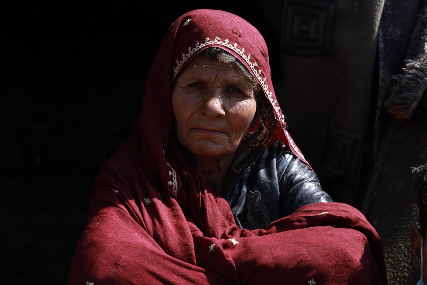 Shayista Gul, 60, and her son Esmatullah, 17, sitting in front of their makeshift shelter on the outskirts of Kabul city. The family have been living in this IDP settlement for 13 years now since the time they have been returned from Pakistan where they lived as a refugee. The family has no source of income since Esmat lost his father in an explosion in east Nangarhar province who was the primary income generator of the family. Now, 15 people, including Shayista’s daughter and her children, who also lost her husband in the same explosion are living in a two-room makeshift home.

Quotes from Shayista: “Since the outbreak of this diseases the price of food items are raised to double folded. I went to a nearby shop this morning to buy soap and detergents, but I could not buy it as the price was increased. Now, I’m washing my clothes only with water without using any detergents.” “we are staying on government owned land and there is no borewell or water tap close to the settlement. It takes at least five minutes to fetch water from a well inside another colony.” 

“We usually rely on community donation here and I heard that price of a bag of flour had increased by 1200 (approx. $16) yesterday and in this case, families might not have sufficient food themselves to help us anymore. We noticed that everyone who could afford was rationing foods and we are just left like that. If things get worse in the coming days or weeks and food and vegetables falls short and shops remain close, we will be left hungry and might lose our loved ones.” “even if the government ask us to stay at our homes, we can’t. we have to collect scrap to feed our children. If not, we die out of hunger and not having food. If Coronavirus do not kill us, hunger will, definitely.”  
Photo: Enayatullah Azad / NRC
