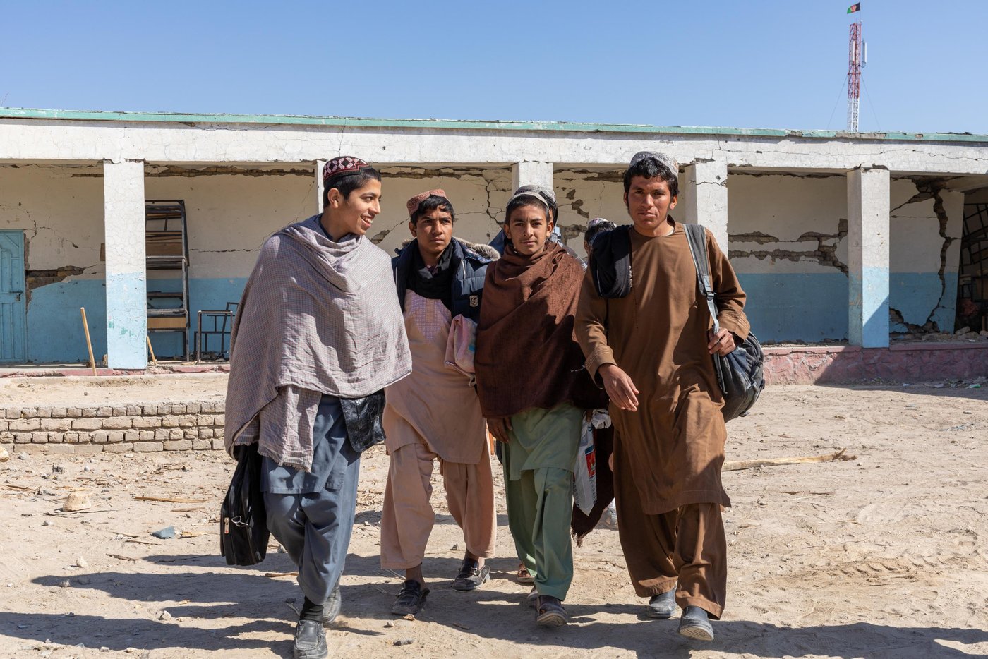 Ahsanullah, 15, an eighth-grade student, recalls the incident and explains the aftermath of the attack on his fellow classmates. Ahsan’s classroom is among those that has been damaged by the explosion so his class was shifted to another room with only minor cracks on the walls. Other students have been shifted to temporary classrooms in tents provided by NRC.
Ahsan and his friends take me to their original class and show me where he was sitting. He also took me to those classes that have been flattened.
“Since the security situation has deteriorated in the area, the government has banned all the motorbikes and those students living in far-away villages can’t get to the school.
Ahsan lives in far distance from school and it takes him and his friends an hour and half to reach to school. They usually collect money to pay for the petrol and use one bike to get to school. Now, as there is ban on the motorbike riders in the district, some of his friends can’t make it to school.
Photo: Enayatullah Azad / NRC