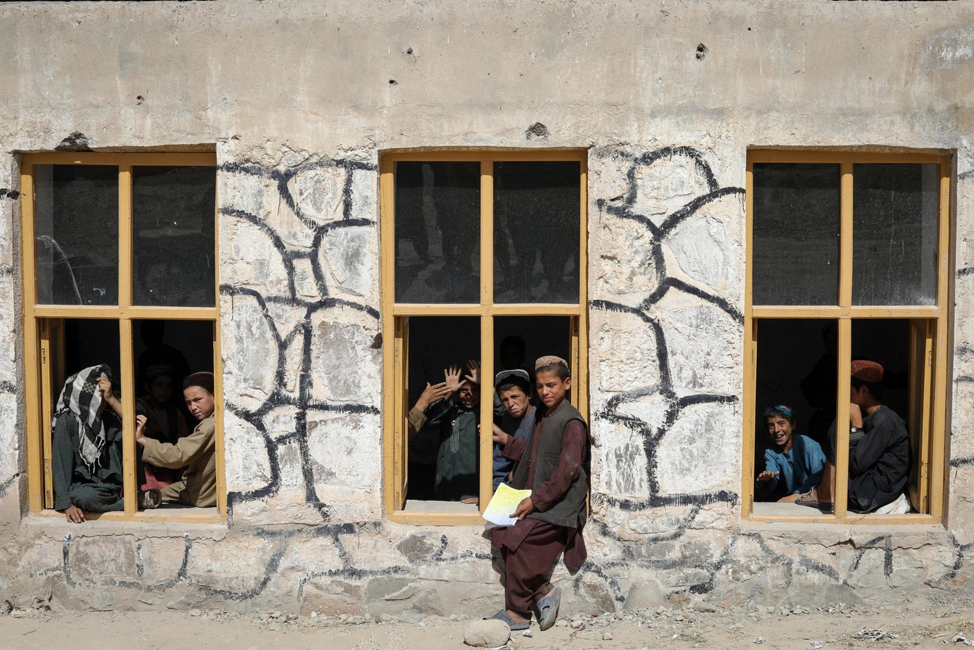 This is Charamgar secondary school some 5KM on the northern side of Trinkot, Uruzgan Province. This school was occupied and used as a checkpoint by the Taliban for almost six months in 2015/16, but the school remain shut for whole academic year. When the the Taliban were moved back and school resumed again, all the roofing, boundary walls and gates were either destroyed or was stolen.
NRC stepped forward and started doing some basic security upgrading to this and some three other schools in and around Trin Kot. The work includes; Iron sheets for the roofing of schools, installing emergency gates, main gates, building boundaries walls, grill work, windows repairing, glasses and blast films for the windows. NRC also established a schools-based Protection Committee (SBPCs) for each school with support and participation of PED, Community shura.
The school activities are closely monitored and checked by the community people, PED and the community has also been accountable to protect the schools from future expected incidents and they are also encouraging the families to get their children to school.
Repairing work and studies continues in this school and currently around 15 staff are teaching some 600 students in two different shifts.
“We feel more safe and secure now after building the boundary walls and installing the gates. Now, we have bigger yard and students can play inside the school building. The boundary is also keeping safe from any attack and flying bullets,” said Nida Mohammad, the Chramgar school principle.
Photo: NRC/Enayatullah Azad