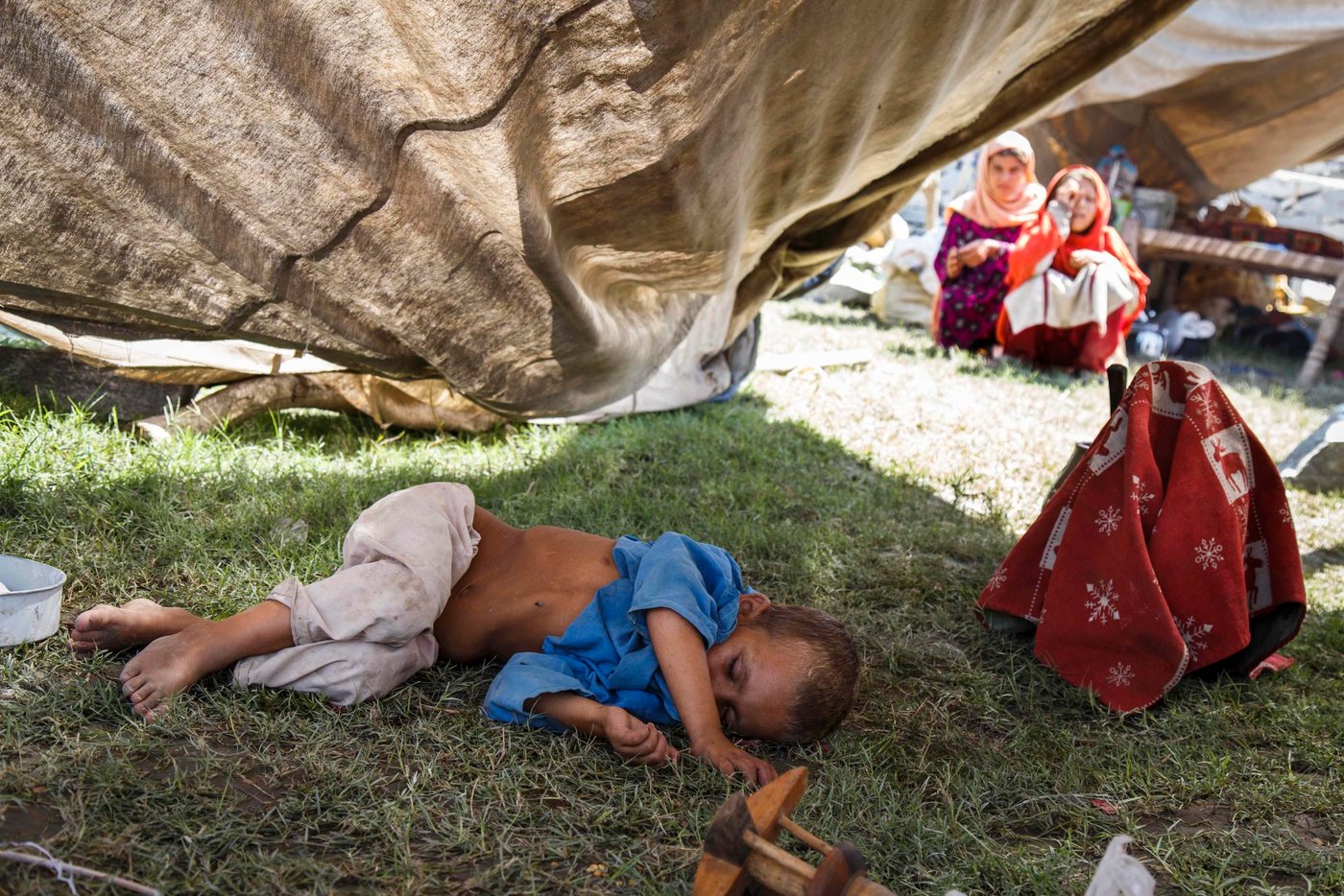 This boy is exhausted and malnourished after his family felt forced to flee their lives as refugees in Pakistan and return to Afghanistan.  He lies underneath a half-collapsed, aging tent. (Photo: NRC/Jim Huylebroek)