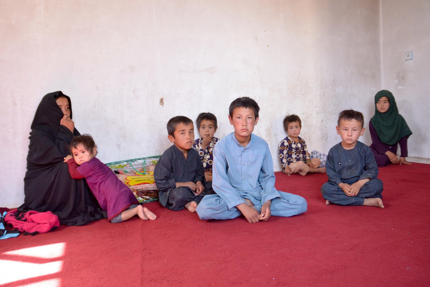 Dordana, 47, and her sister-in-law, Marzia, 28, have left with thirteen children. All male family members even the seventeen-year-old Baqir were killed during the Mirza Olang attack on August 5.
The armed militant group blocked the way while the family were fleeing from the village. The Taliban have separated the male family members and killed and took the women hostage.
Dordana, her sister in law and the children fled after three nights being hostage in their homes in Mirza Olang village.
NRC with support from ECHO have responded to the family with 28,000 AFS in order to cover the needs in terms of Shelter, fuel, electricity, health, and transportation.
Photo: NRC/Enayatullah Azad