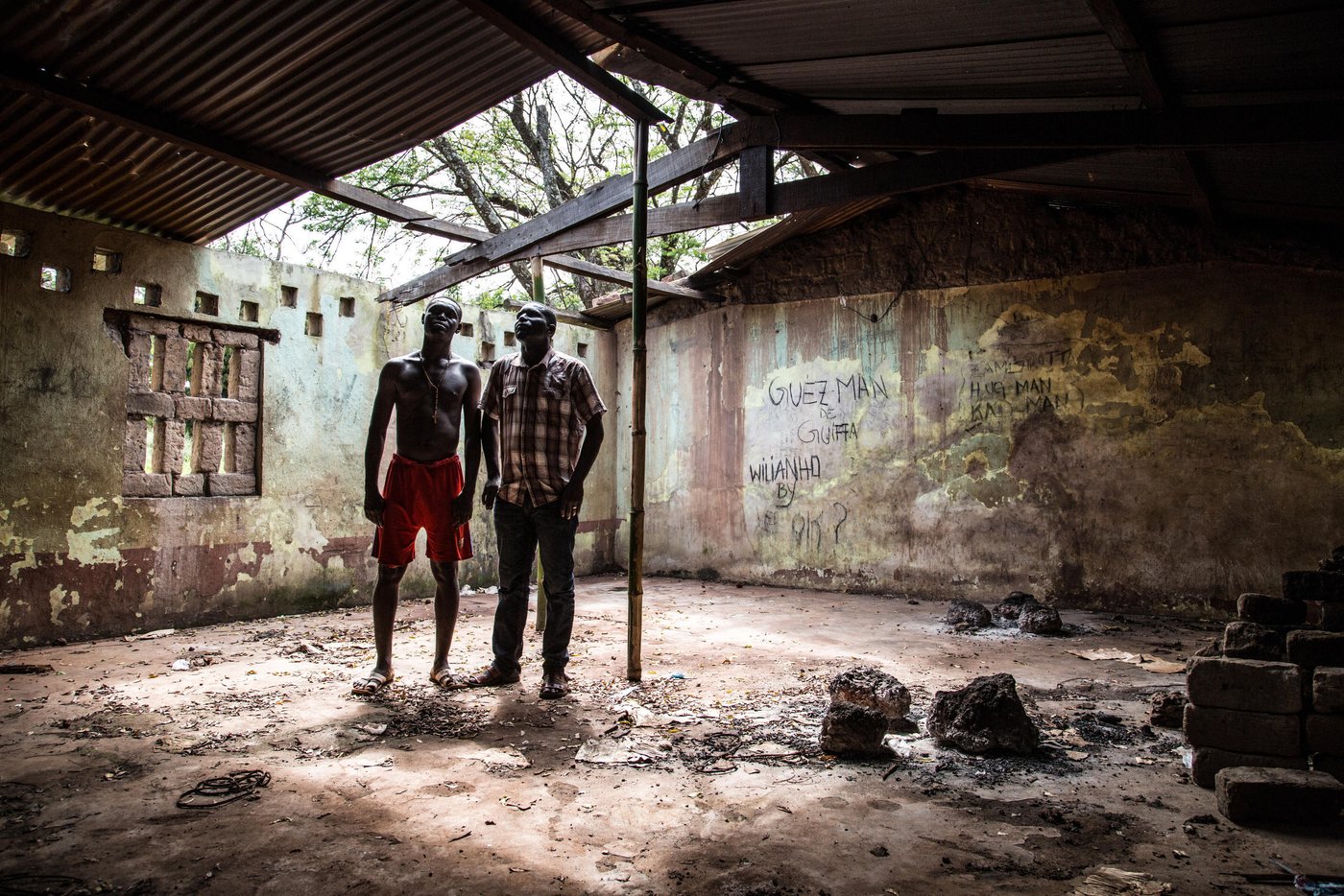 ENGLISH:
Deko - destroyed school. 
On November 7, 2014, Paulin finally returned to Dekoa for a short visit. When he arrived, he started by walking around the town with his brother, who he has just found again. The town school has been closed since November 28, 2012; Paulin observes the damage. There are no more instructors; all of them left and have not come back. The start of the school year will not take place on the date scheduled on the official calendar (November 20, 2014).

FRENCH:
Le 7 novembre 2014, Paulin est finalement retourné à Dekoa pour une brève visite. A son arrivée, il entame un tour de la commune en compagnie de son frère qu’il vient de retrouver. A l’école de la ville, fermée depuis le 28 novembre 2012, Paulin constate les dégâts. Il n’y a plus d’enseignants, tous sont partis et ne sont pas revenus. La rentrée scolaire n’aura pas lieu à la date prévue par le calendrier officiel (20 novembre 2014).

November 2014. Photo: NRC/ Vincent Tremeau