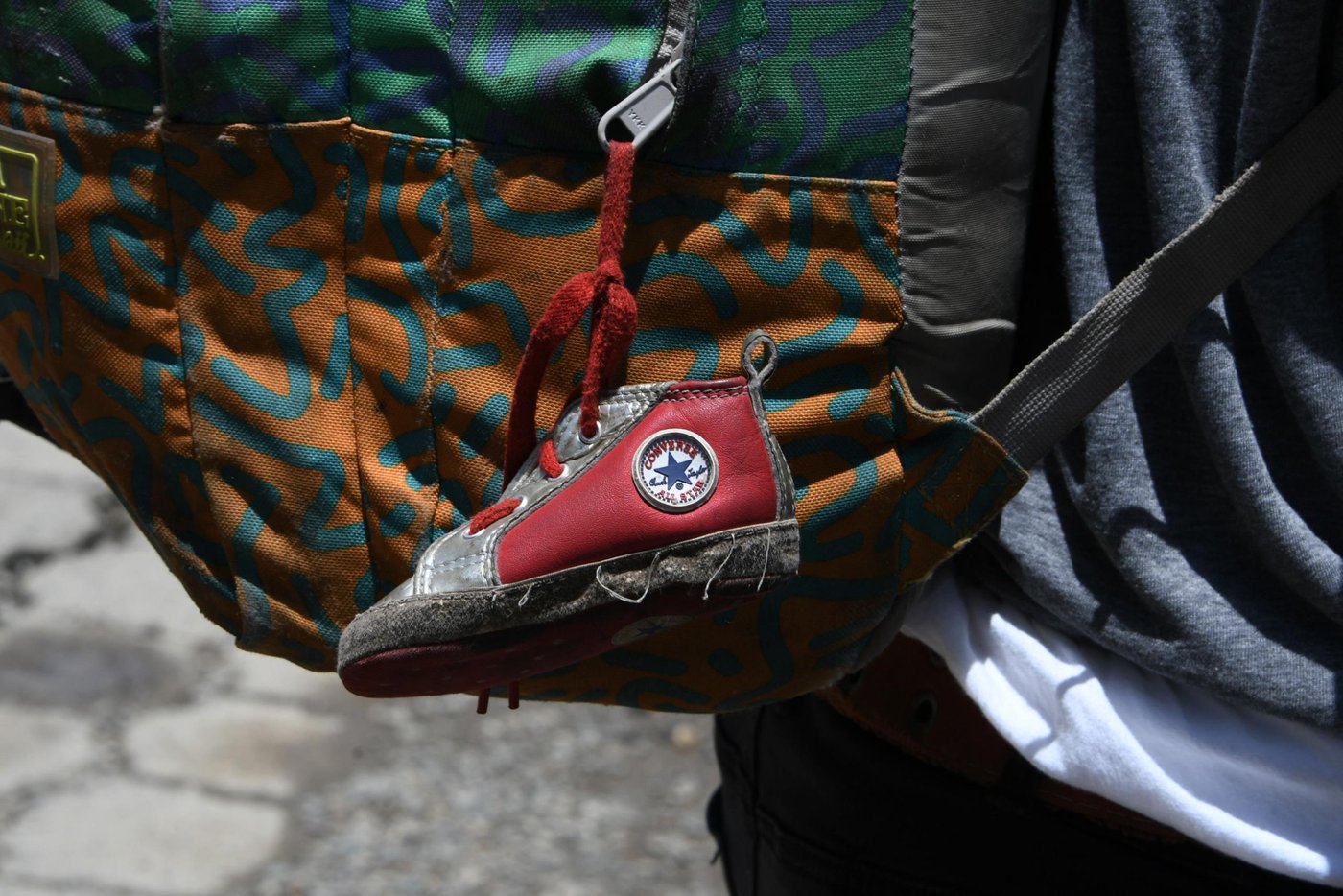 A little shoe that belongs to his baby girl hangs from the backpack of Honduran immigrant Ever Sierra, 28, who was deported from the US and arrived in San Pedro Sula, 200 kilometres north of Tegucigalpa on June 22, 2018.
Ever, was separated form his wife, Iris Yaneth, 26, and their eight-month daughter to be locked up in a detention center in McAllen, Texas, US and then in Lousiana before being deported. Notwithstanding the struggle, Ever is determined to resume in the next few hours his return to the US, where he hopes to reunite with his family. / AFP PHOTO / ORLANDO SIERRA