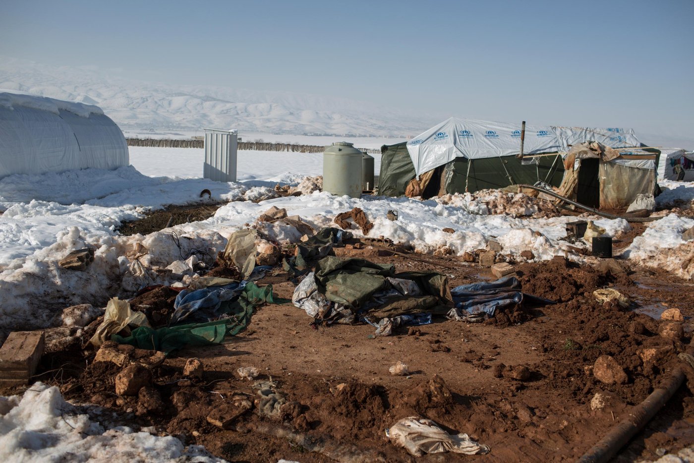 Bare earth shows through the snow where a tent was recently destroyed by heavy snowfall at an informal tented settlement for Syrian refugees in the Bekaa Valley, Lebanon.

As Storm Zina raged across Lebanon, hundreds of vulnerable Syrian refugee families, particularly in the Bekaa Valley, have been badly affected as temperatures fell well below zero and more than 25cms of snow fell. NRC staff distributed wood and plastic sheeting to allow refugees to reinforce their tents in order to prevent them from leaking and from collapsing under the weight of snow. Floor raising kits were also distributed to lift the base of tents away from the frozen ground and to protect against flooding when the snow melts. Drainage kits and sand bags were distributed as well to allow refugees to protect tents and latrines from flooding once the thaw begins. NRC has also delivered clean drinking water where water supplies were frozen and, where meltwater is filling up septic tanks, NRC is ensuring they are emptied safely.

Photo taken on Wednesday January 14.

NRC/Sam Tarling