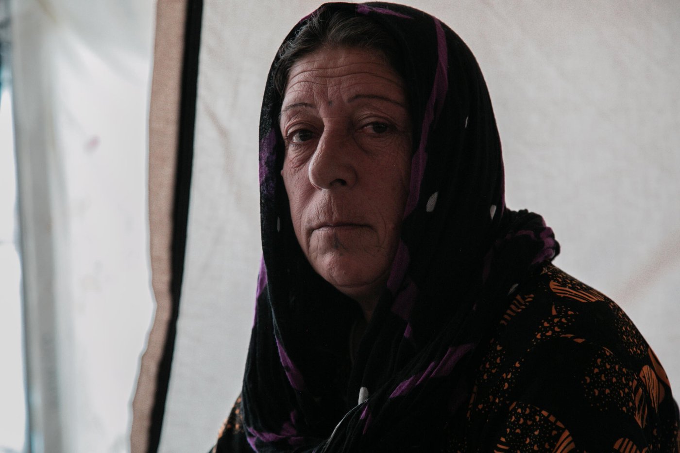 Sorya Ahmed, 55, a grandmother from Ras Al Ayn. When Turkey announced their military operations in north east Syria she moved to different locations hoping that the situation would calm down, however things were escalating and the fighting was reaching them from one village to another. Eventually, Sorya and her family decided to leave Syria and seek refuge in Kurdistan Region of Iraq. Sorya has been displaced three times during eight years of war but this time was more horrifying than any time before. 
“We saw people burning in front of us. We escaped running over their dead bodies, there were no safe routes to escape, and they did not secure a road for civilians to leave.”
“We were 23 people; there were kids, women and young men with us. The smugglers were asking for a big amount of money. We did not have any money but we had my son's car, so we gave them the car instead of money.”
“At the border, we walked for around six hours. We were so scared that ISIS or anyone else would attack us. All of these children were with us without water and food.”
“On the way, we did not know who we are dealing with. Even men started to get scared because we no longer knew where we were going.”
“There is nothing to go back to, they burnt my house, and in Ras Al Ayn the original people of the area have left (now is full of Arabs and people from other areas). Even if I eat soil here I would not go back to Syria.”


Photo: Alan Ayoubi/NRC
Date: 02 December 2019
