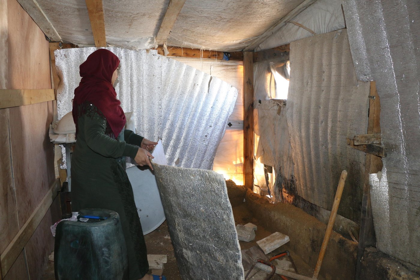 Intisar and her family , who fled to Lebanon in 2013, live in one of those settlements. Without proper walls to protect them from the stormy winter weather, their tent flooded. The family was forced to evacuate.
“My family and I are sleeping in a relative’s tent until the floor dries,” Intisar explains. “All our mattresses, blankets and pillows are soaking wet. We are trying to dry them outside but there is barely any sun.”
“I’m constantly worried about the rain and wind. The other day the wind was so strong that the tent almost collapsed on our heads. The rain was pouring in from the ceiling and window, leaving the whole tent flooded.”
Refugees represent over a quarter of Lebanon’s total population. This has created a huge strain on the country’s infrastructure and public services. Refugees cannot legally work, and frequently struggle to meet their essential needs. Seventy-three percent of Syrian refugee households live below the national poverty line.
Since fleeing Syria, Intisar’s family have had to rely on their eldest son, Majd, to make ends meet. Majd is now 18 and been working since he was just 14. He is often separated from his family for long periods of time to avoid transport costs.
“Majd breaks my heart,” says Intisar, tearfully. “His childhood was taken from him and he had to quit school to provide for us. No child should have to take responsibility for their family.”
Living in informal settlements, especially in wintry conditions, can have a significant impact on refugees’ health. Intisar’s family is unfortunately no exception.
“It is very distressing to live like this. I’m constantly worried about my family and the health of my children. The most challenging part of life here is when your child becomes sick and you can’t take him or her to a doctor to get treatment. My son and daughter both need medication that we can’t afford,” says Intisar.
Photo: Racha El Daoi/NRC