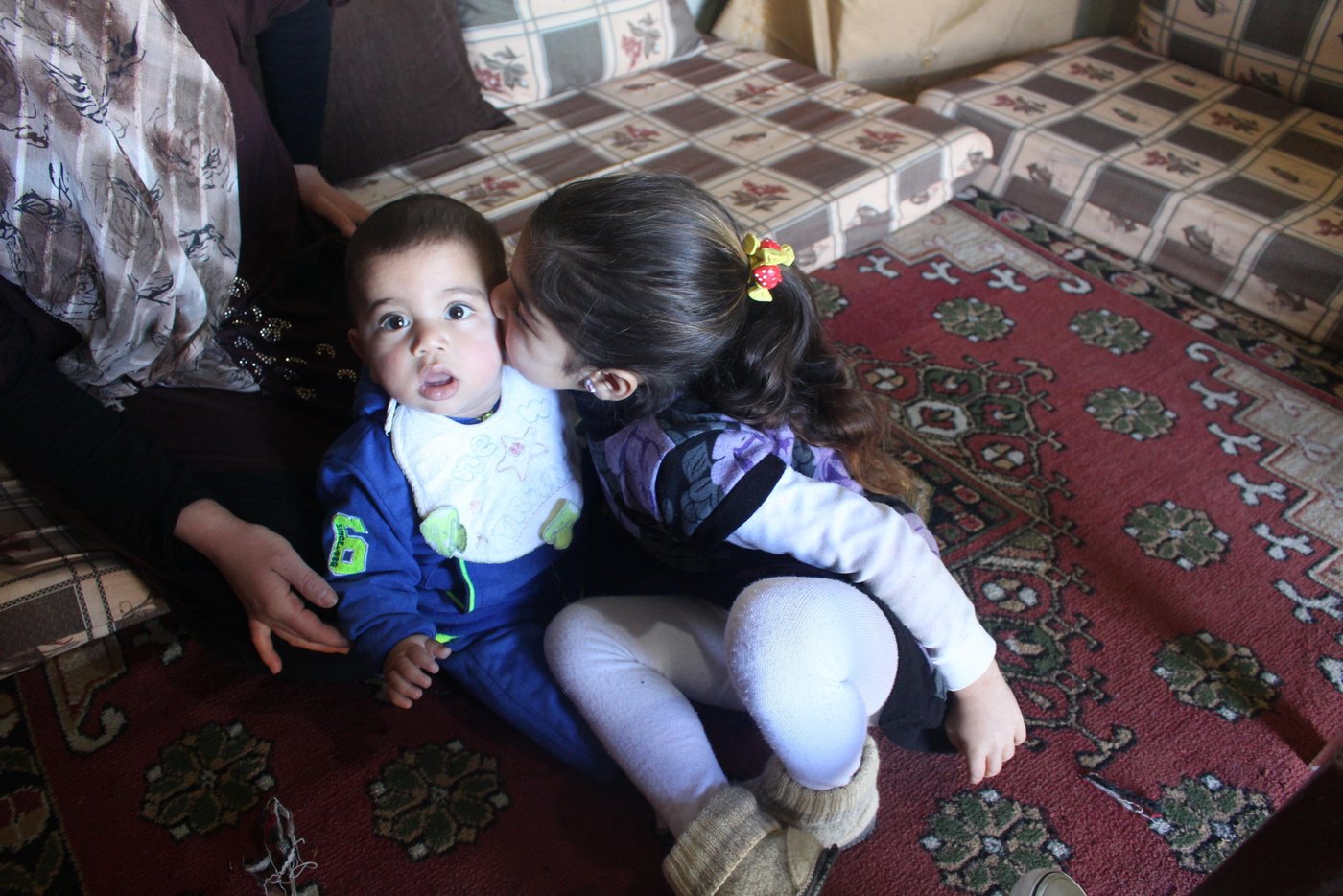 Ilham kisses her younger brother Youssef, 9 months old, in the family's living room in South Lebanon. Youssef was born in Lebanon and his parents have not yet registered his birth, which makes him at risk of being stateless. NRC’s Information, Counselling, and Legal Assistance (ICLA) team are supporting Youssef’s parents to formally record Youssef’s birth.

Photo: NRC/Rayane Abou Jaoude