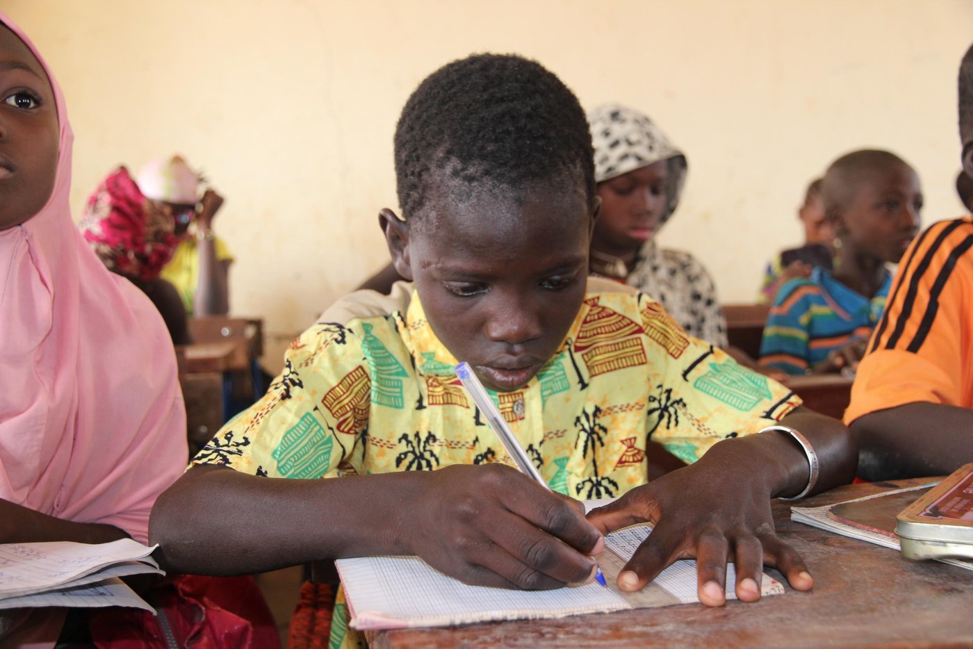 Kayma is 12 years old. He lives with his family in the village of Bargondaga. The family is of the Bozo tribe, who traditionally are fishermen. 

Kayma speaks both Bozo language and Bambara language; both are among the 13 acknowledged national languages, besides French which is the official language of Mali.

Kayma attended the NRC accelerated learning program in the village. After graduation, he was able to attend the local official school of Bargondaga. He is now in the fourth grade, and he is a bright boy: “I started late at school because I had no birth certificate, but now I am going to work hard in order to be successful.” After only seven months at school, Kayma is already the second best of the 78 pupils in his class! And school is important to Kayma. Before leaving home, he changes clothes from the ones he plays in at home, to something better. He likes to look decent at school. 

His favorite subjects are writing and history, and when he grows older, Kayma wants to be a teacher. The school is approx. three kilometer from home and Kayma rides on an old bicycle to be able to reach school in time. 

(see also Kayma`s story under “ICLA”)

The school that Kayma attends is Ecole de Bargondaga, it has 181 pupils from first to sixth grade and 116 students from seventh to ninth grade. The school offers both accelerated learning programs and ordinary school. The age of the pupils and students in each grade differs, because the pupils are divided after skills and not age.

The school bell is an old rims hanging from a tree in the school yard, and because clean water is a problem in the area, the school well is popular among the pupils. 

The school also offers exam preparations for students from another village across the river. The area there is more insecure, so the students live at the Bargondaga school. After graduation they return to their own village.

NRC has supported the school with school bags, books and pencils for the younger pupils, which their families would not be able to buy themselves. 

In and around the cities of Mopti, Gao and Tombouctou, NRC has offices and extensive programs:
•	Education: In collaboration with beneficiary groups, local stakeholders and education authorities NRC provides accelerated learning programs and formal education for children. YEP-programs are established in Mopti, Gao and Tombouctou. Beneficiaries 2015: 8.249 children and youth (education, YEP, school kits). 66 classrooms have been renovated.
•	ICLA: NRC assists displaced and vulnerable people to acquire civil documentation (National ID, Birth Certificate) and rights for housing, land and properties (HLP). Without ID or birth certificate, it is difficult to get access to public services and rights, and people without ID are effectively barred from entering the formal economy, health care and formal education. People moving through the country without a document are also vulnerable to the predations of state security forces who can detain them and extract bribes or subject them to physical abuse – with risks especially high for women. Beneficiaries 2015: 23.381 (sensitized, civil- and land documents) 200 local authorities have been trained.

 Photo: NRC/Ingrid Prestetun