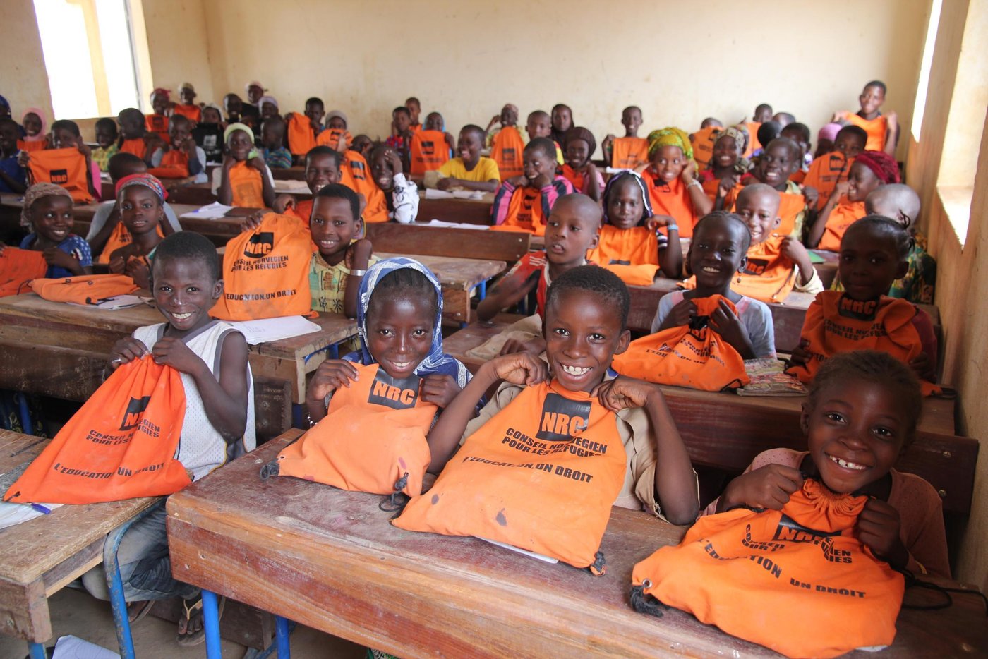 Photo: NRC/Ingrid Prestetun 

The school these children attend is the Ecole de Bargondaga, which has 181 pupils from first to sixth grade and 116 students from seventh to ninth grade. The school offers both accelerated learning programs and ordinary school. The age of the pupils and students in each grade differs, because the pupils are divided after skill and not age.
The school bell is an old rims hanging from a tree in the school yard, and because clean water is a problem in the area, the school well is popular among the pupils. 

The school also offers exam preparations for students from another village across the river. The area there is more insecure, so the students live at the Bargondaga school. After graduation they return to their own village.

NRC has supported the school with school bags, books and pencils for the younger pupils, which their families would not be able to buy themselves. 

In and around the cities of Mopti, Gao and Tombouctou, NRC has offices and extensive programs:
•	Education: In collaboration with beneficiary groups, local stakeholders and education authorities NRC provides accelerated learning programs and formal education for children. YEP-programs are established in Mopti, Gao and Tombouctou. Beneficiaries 2015: 8.249 children and youth (education, YEP, school kits). 66 classrooms have been renovated.
