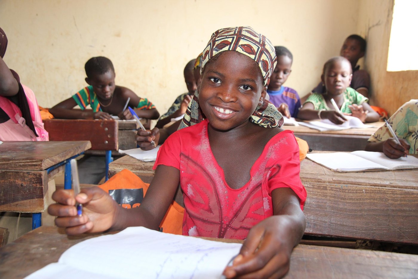 Aissata Traore (girl, red dress) is 10 years old. She is in third grade. She likes to go to school, and her favorite subject is mathematics. Aissata has one little sister at school, in addition to one little brother and two small sisters at home, who all are too small for school. When not at school, Aissata does her homework and helps her mother cleaning the house. 

Her dream for the future is to be a teacher – or may be a princess, she says!

The school which Aissata attends is Ecole de Bargondaga, it has 181 pupils from first to sixth grade and 116 students from seventh to ninth grade. The school offers both accelerated learning programs and ordinary school. The age of the pupils and students in each grade differs, because the pupils are divided after skills and not age.

The school bell is an old rims hanging from a tree in the school yard, and because clean water is a problem in the area, the school well is popular among the pupils. 

The school also offers exam preparations for students from another village across the river. The area there is more insecure, so the students live at the Bargondaga school. After graduation they return to their own village.

NRC has supported the school with school bags, books and pencils for the younger pupils, which their families would not be able to buy themselves. 

In and around the cities of Mopti, Gao and Tombouctou, NRC has offices and extensive programs:
•	Education: In collaboration with beneficiary groups, local stakeholders and education authorities NRC provides accelerated learning programs and formal education for children. YEP-programs are established in Mopti, Gao and Tombouctou. Beneficiaries 2015: 8.249 children and youth (education, YEP, school kits). 66 classrooms have been renovated.


 Photo: NRC/Ingrid Prestetun