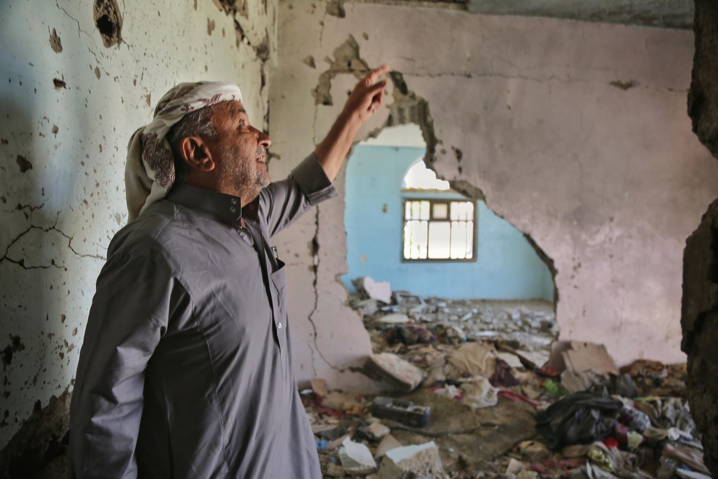 Abdullah Hasan Al-Shara’ai, aged 65, points out the extensive damage to his home in Taiz city, which he used to partially rent out for an income. 

When the fighting reached his neighborhood in Taiz city, Abdullah took his family and fled the area, leaving everything behind. “We didn’t think about anything but how to flee. Our souls are the most valuable thing. Everything else can be fixed.” 

He took shelter in an empty hotel, alongside other displaced people. When the battles eased somewhat, he returned to check on his home, but found it had been badly damaged. He gathered the remnants of the shells that had struck his building and kept them.

“The home was damaged and everything inside it was destroyed. I lost everything I have and now I live inside two rooms in a hotel,” he says. Abdullah's son broke his leg fleeing gunshots, and has not walked since. 

Abdullah is one of 100 families in Taiz city who have received financial assistance to cover his shelter costs, from the Norwegian Refugee Council within funding from the German government. Abdullah remembers what it was like to be a landlord with his own tenants. He says he often allowed his tenants to miss or reduce rental payments when they were in trouble. “I wasn’t tough on anyone. Some used to pay YR13,000 and others YR15,000 and sometimes nothing.” 

Back then, Abdullah says, “I was satisfied with my income. If you are satisfied with what Allah gives you, you will be the richest one." 

Photo: Khalid Al-Banna/NRC