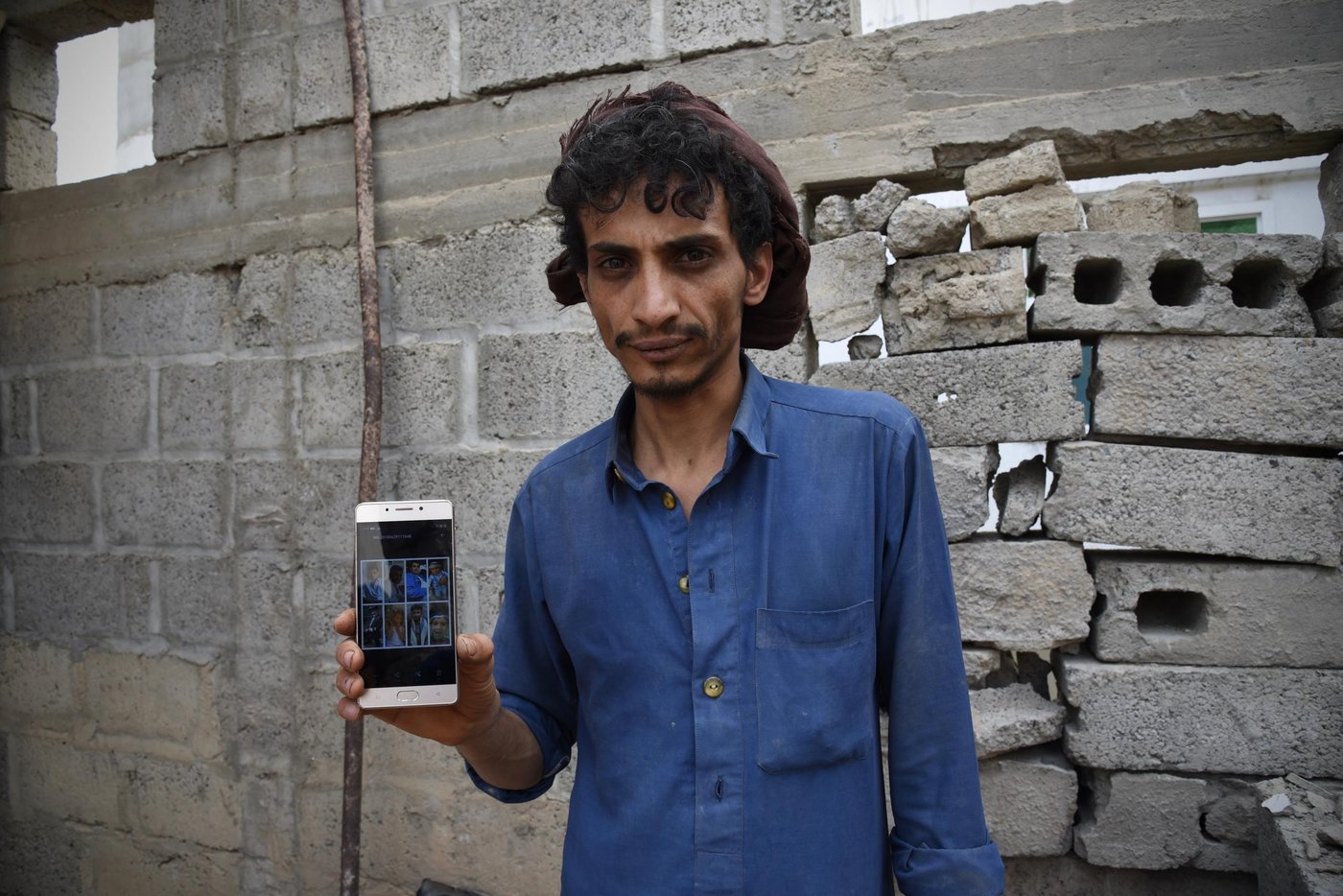 “Khalas. There is no more future. Nothing to look forward to anymore.”
Yusuf’s family has lived in the same house in Amran for over 30 years. It’s the house he was born and raised in. As Yusuf and his five siblings got married and had children of their own, the house was filled with more family members. Yusuf and his wife have a three-month-old son and a two-year-old daughter.
After Ramadan this year, on 23 June, the family’s life was irreparably changed. Yusuf woke up at around 2 pm to extremely loud noises and a shaking house as three bombs hit their neighbour.
“Whenever there is an airstrike, we all gather on the first floor. We usually wait for 30 minutes before we go back to our rooms and back to bed. So we did the same that night; as we didn’t hear anything more after 30 minutes, we all went back to bed,” Yusuf said.
After a couple of minutes a fourth strike hit. This time the bomb landed on Yusuf’s family home.
“I got up from bed and tried flicking on the light, but the electricity had been cut. I found my phone and lit up the room. That’s when I saw that all our doors had been blown down,” he said.
The wall separating his room from the room of his brother and sister-in-law had also been blown apart. Yusuf walked in with his phone in his hand.
“On the floor, I found my brother’s wife dead. Half of her head had been blown off.”
Yusuf started searching frantically for his other family members, eight of whom were buried alive. Four of the dead were his cousins, all under the age of 13, with the youngest only eight months old. Two others were severly injured.
“We spent two hours trying to pull everyone up from under the rubble. Meanwhile jets were still hovering over our heads and we were afraid of new airstrikes,” Yusuf said.
Three other neighbours were killed that night. A total of five houses and a mosque were bombed.
“I am heartbroken,” Yusuf said. “My father and mother spend their days either crying or not saying a word. My father refuses to look at photos of my brothers and their families who died that day. He can’t look at them. I try my best to keep them occupied.”
When asked what he wants the rest of the world to know about the situation for civilians in Yemen, Yusuf answered:
“They are targeting civilians more than each other. This war on innocent people must stop.”
Before they died, Yusuf’s two older brothers provided for the family and kept the hosusehold going. Yusuf has started selling the remaining family’s belongings to afford basic necessities.
“My white hairs came after the airstrikes,” Yusuf said. “My only goal for now is to feed the children.”
Yusuf told NRC staff that he doesn’t have anywhere else to go:
“Staying in our damaged home is better than having no home at all,” he said.
Photo: Becky Bakr Abdulla/NRC