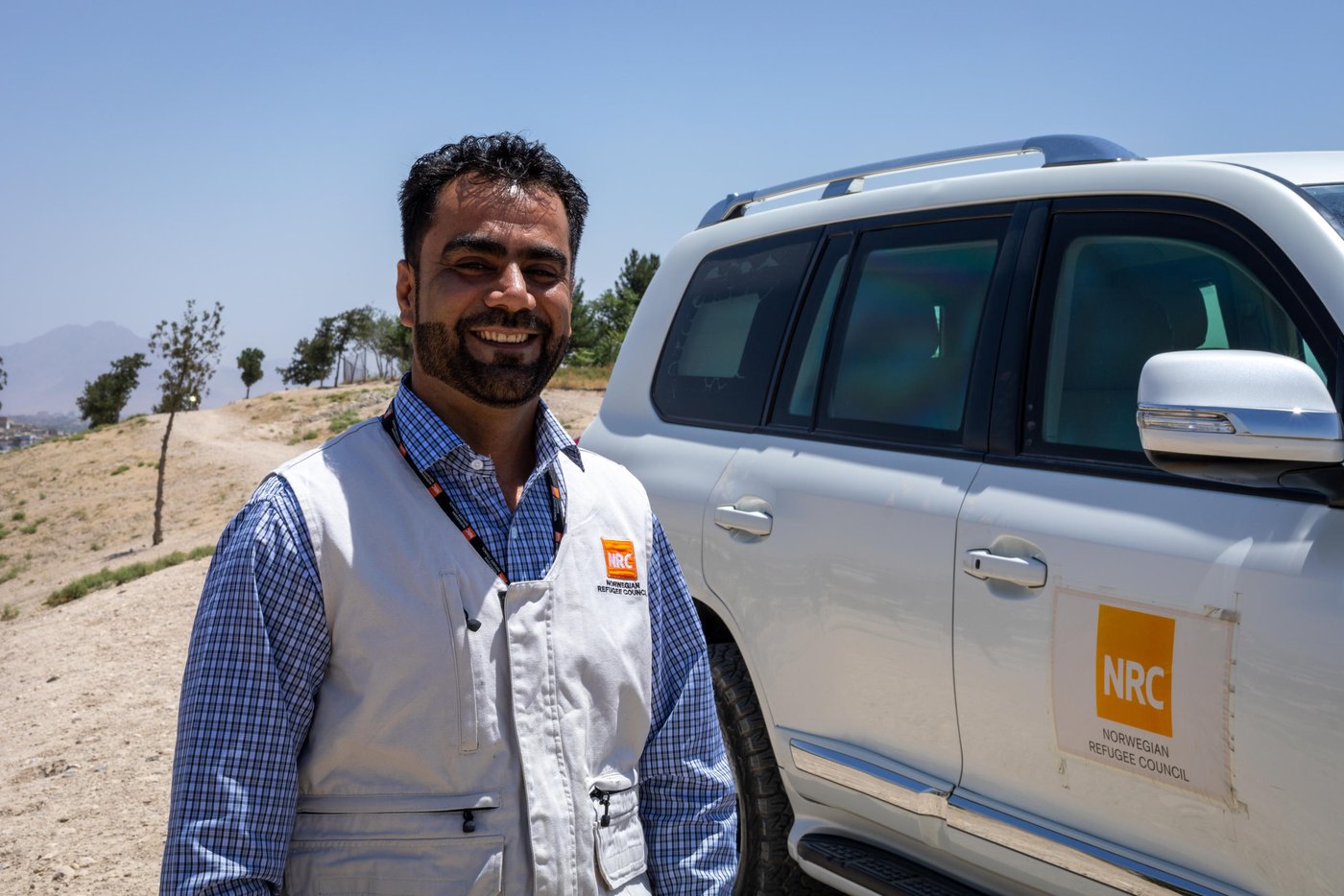 Murtaza Sarwari, 42, has been working for NRC Afghanistan since 2008. He joined NRC as a driver after finishing his job contract with the Japan embassy in Kabul. He starts at 6:00 in the morning, and gets off the wheel around 8:00 p.m. three days a week. As the COVID-19 pandemic continues, he is normally reporting to his job and risking his personal health to help delivering to the people in need.
Quotes:
"I worked as usual during this pandemic. It was an emergency period and we had to stay open and deliver to those in need.”
“There were many people in camps and settlements that needed our help and support. There were many families that were not able to even buy washing soap or shampoos if we weren’t there to support and that was more of a reason for all of us to continue working.”
“I have remained a humanitarian for almost one and half decade and I wanted always to help people and this was the right time. When the situation comes, we have to dive into dangers for the well-being of others and that’s our job as a humanitarian aid worker.”
“Though it was a tough time for all of us, specially at the beginning of the pandemic while hearing a lot of rumors, but I do feel happy now and pleased that we stayed and delivered. As it is being said, after every darkness is a light.”
“As a driver, I am trying to do everything I can to make sure that my colleagues and also my family are taken care of and protected. I’m keeping myself sanitized and then, sanitize the vehicle with the doors locked for twenty minutes twice a day, by doing so, I protect everyone in my circle.
“I love my job and I love NRC. However, I feel like we need more protection equipment while travelling between home and office. Most of us use public transportation to get to work and back home, so there are chances that we might get infected in the public. And I think, the office should also think about it. We should be vigilant about our health and safety so that we can stay and deliver on time.
Photo: Enayatullah Azad/ NRC