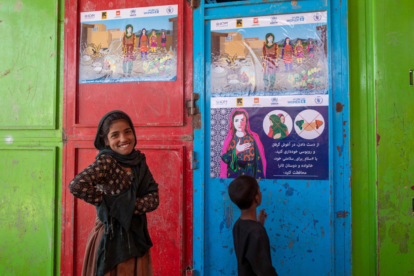 Sayirah, 12, and her little brother in Hiwadwal IDP settlement
 in Kabul. Children in this settlement are among the most vulnerable displaced population in the country. The children here can't read and write but can easily get the COVID-19 message from SalamForSafety posters. Photo: Enayatullah Azad / NRC