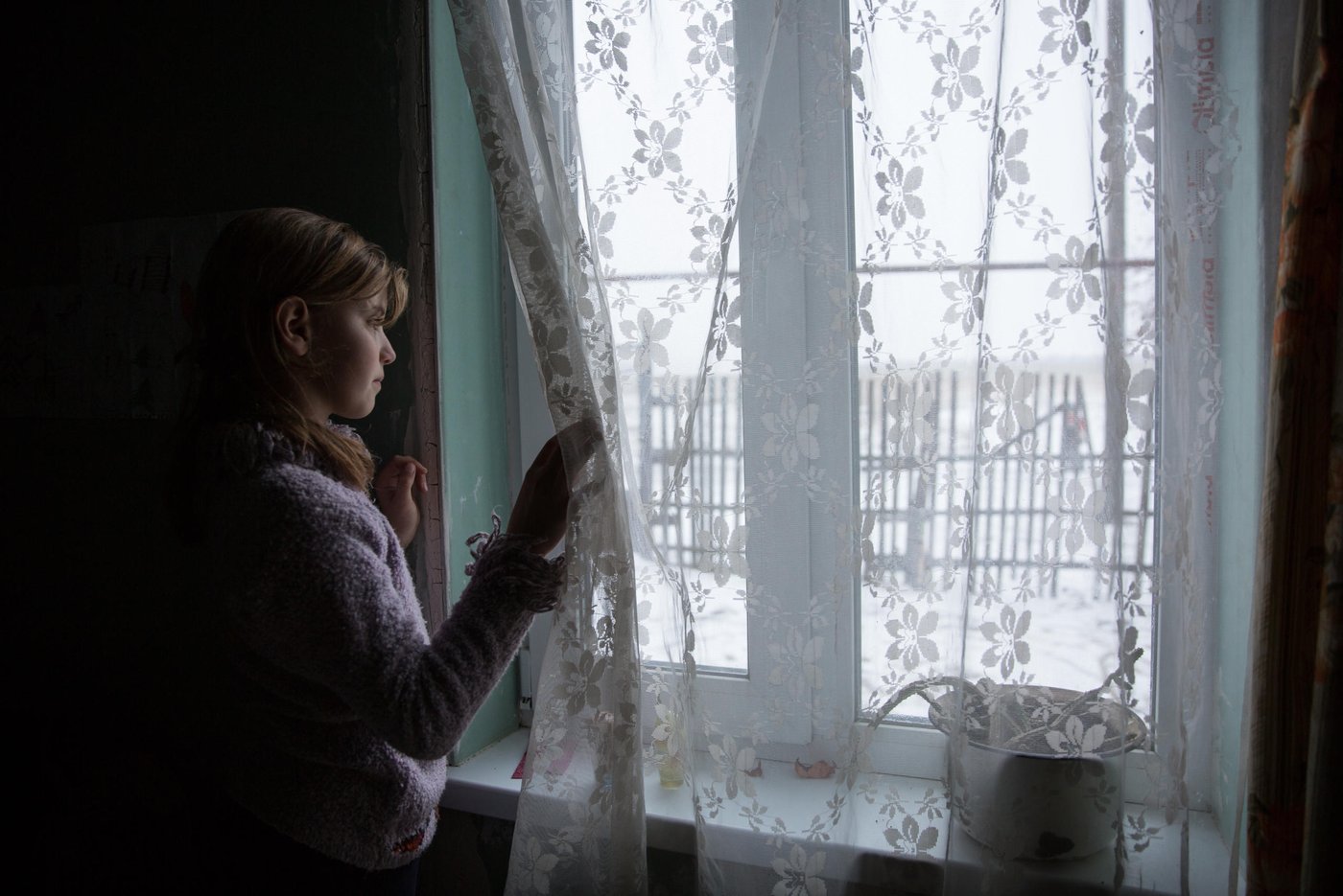 Iryna is 10 years old, and Liliia’s eldest daughter. She still remembers the night their house was hit. Iryna and her sibling all suffer from post-traumatic stress. It is hard to concentrate at school and she has nightmares and anxiety. “The main concern for me now is that the active phase of the war does not break out again. I am afraid that my house will be destroyed again. After all, we hear the sounds of shots every night,”says her mother Liliia. 

Background story:
Liliia Poturoieva is 39. She has experienced terrible events that completely changed the life of herself and her large family and left an indelible mark on everyone's soul. She lives in the frontline village of Verkhnia Vilkhova in Stanytsia Luhanska district, Luhansk region. 

Liliia has six children. The oldest is Oleksandr. He is 20. He lives separately from his parents and earns his own living. Ihor is 12. He is a shy and calm schoolboy, always ready to help parents with the housework. Her eldest daughter Iryna is 10. She is a schoolgirl and mother's main housekeeper. She cooks and looks after younger children. Yana is 7. She is a first-grade pupil. She is a cheerful, active and very energetic girl. The children are forced to go to school in a neighboring village 5 kilometers away, since there is simply no school in their village.

Her youngest son Illia,5, and daughter Aryna, 2, are always staying at home with their mother. The family cannot afford a kindergarten for children. Now Liliia is pregnant again. This will be the seventh child in the family. Her husband Viktor helps her to cope with all of them.

Before the conflict, the whole big family lived in a small house with two rooms. There was no work. The main income was child allowances and random earnings from the cows, goats, rabbits and poultry. 

“There was no work in the village. There was no opportunity to travel to other settlements to work. We tried to make money by selling milk”.

In February 2015, at midnight, heavy shelling began. Viktor, Liliia's husband, went out into the yard to see the direction of the shots. Suddenly a shell fell near their yard, and the second shell landed 7 meters away from Viktor, who was standing on the house porch. Viktor got a serious shell shock and lost his hearing for a while. 
The blast wave knocked out all the windows in the house. Under one of the windows there was a child's bed, where Liliia’s  youngest son slept. That night Liliia saved the life of her son with her son. 

“When the blast hit, I covered my baby with my own body, and the glass from the broken window hit me in the back”.

The consequences of that shelling are still noticeable. Liliia has problems with her speech. She is stuttering. She is not the only one.

“The children experience anxiety, concentration problems, fears and, as a result, urinary incontinence”.

The house was seriously damaged in the blast. All the windows were broken, the front walls were destroyed and the roof and the foundation were seriously damaged. However, Liliia and her family did not dare to leave because it was too risky to leave the house unattended. They tried to repair the house on their own. They covered the broken windows with plastic wrap. They even had to spend their nights in the basement because it was the warmest and the safest place in their household.There was no help from the local authorities. 

“At first I didn’t want to ask for help. I did not believe that anyone would really help us. My husband advised me to go to the NRC office and find out about the Heavy repair project, because he heard that NRC had already helped someone in the village”.

Now the house is in the process of restoration. There is a new slate on the roof. Renovation works on the walls have been completed. Three small rooms for the children have been completed. New windows have been installed and internal works are being carried out now.

 “The main thing for me now is that the active phase of the war does not break out again. I am afraid that my house will be destroyed again. After all, we hear the sounds of shots every night”, Liliia says. 

Photo: Ingebjørg Kårstad/Norwegian Refugee Council