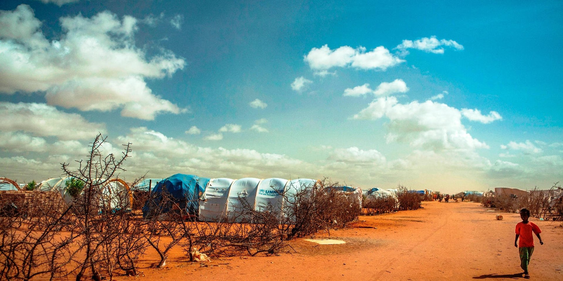 The Dadaab camps (Ifo, Dagahaley, Hagadera) were constructed in the early 1990s. Ifo camp was first settled by refugees from the civil war in Somalia and later efforts were made by UNHCR to improve the camp. In 2006, flooding severely affected the region. More than 2,000 homes in the Ifo refugee camp were destroyed, forcing the relocation of more than 10,000 refugees. Here a boy walks between two 'blocks' in Ifo camp of Dadaab, the world’s largest refugee camp with 464,000 registered refugees, 115,000 of which arrived in 2011 from southern Somalia due to conflict and drought. 29May12.