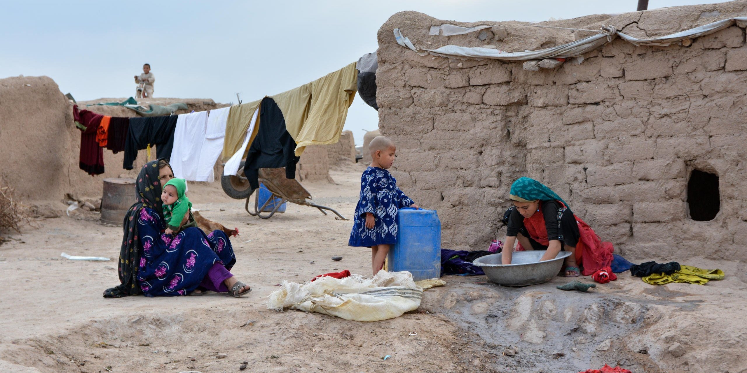 Women and girls in Police Rah camp. They take water from the only tank outside the camp, washes clothes and cooking while men are going for daily labor works inside Herat city. There is only one water tank outside camp and the water runs off many hours during a day. NRC/Enayatullah Azad