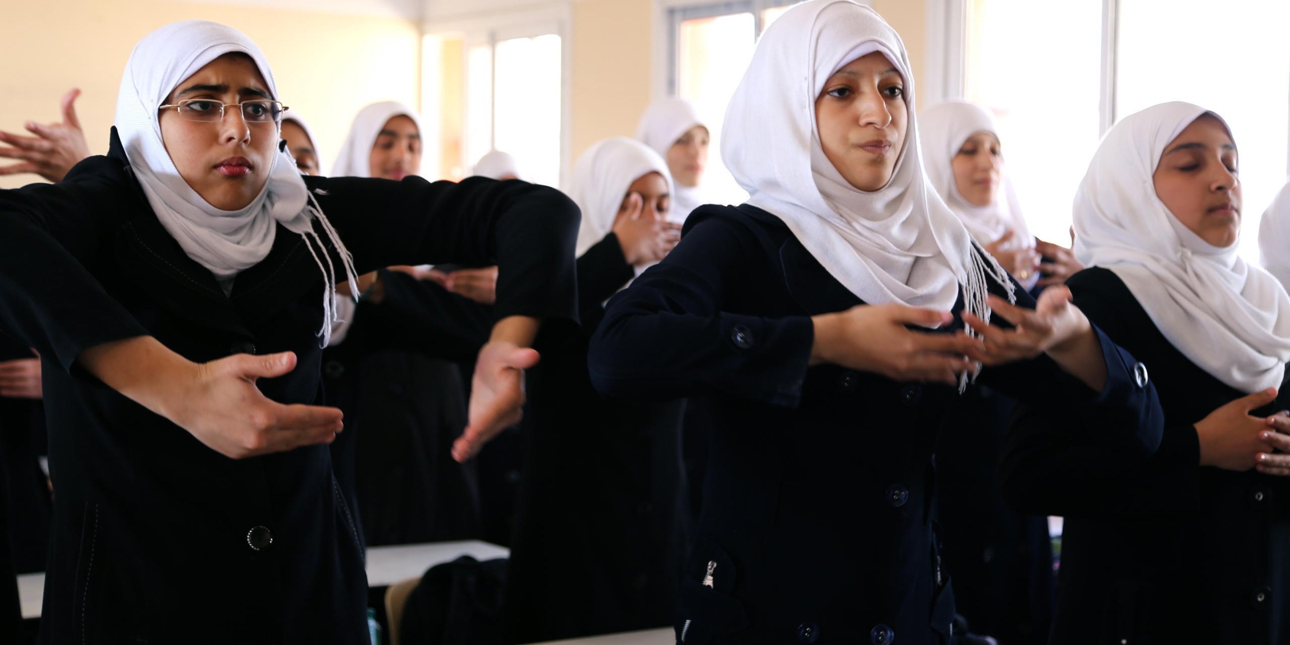 Ain Jalout Secondary Girls School- MoEHE. Students with their teacher practicing the breathing exercise