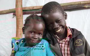 Danielboy og lillesøsteren Eve Dawa holder rundt hverandre og smiler.