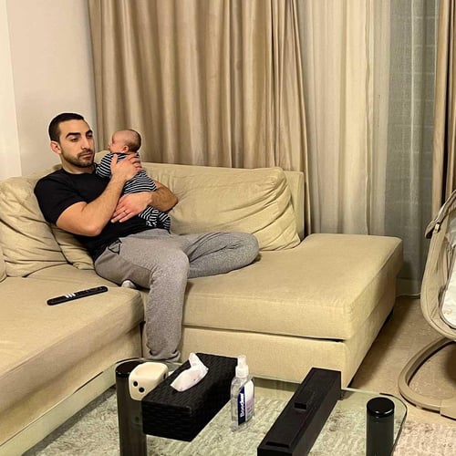 A father and his baby, watching the news at home