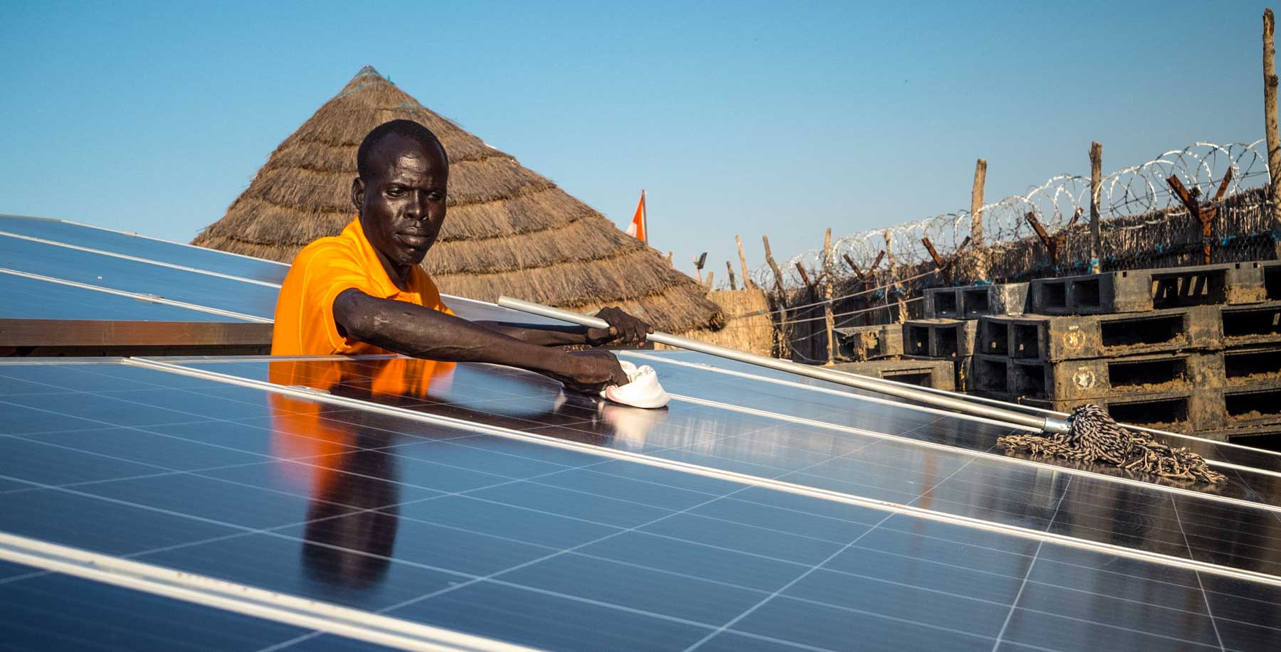 New solar panels being cleaned for optimal results by local volunteer Michael Gatluak at the Norwegian Refugee Council's office in Mankien, South Sudan.