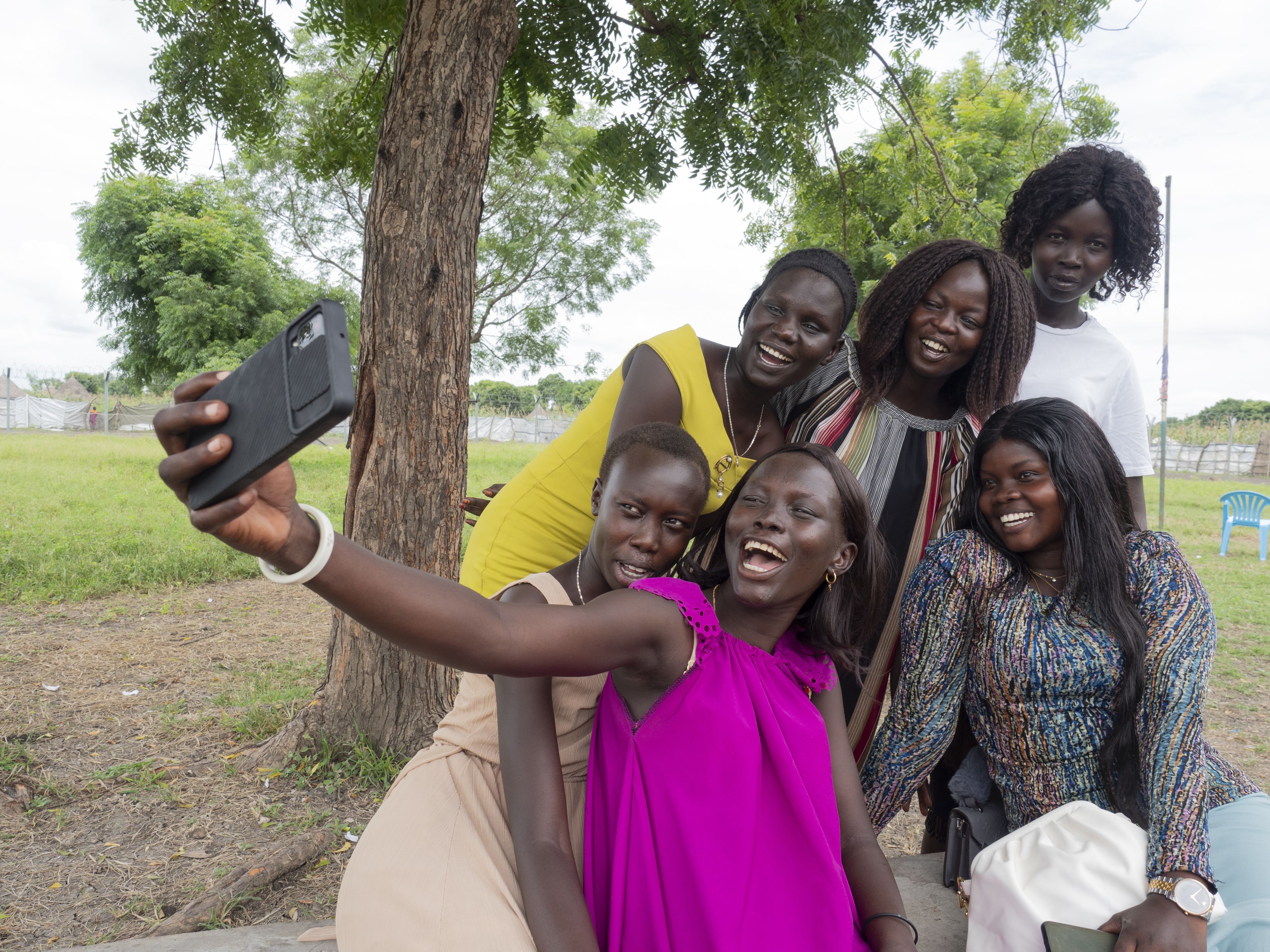 Seks unge kvinner tar en gruppeselfie.