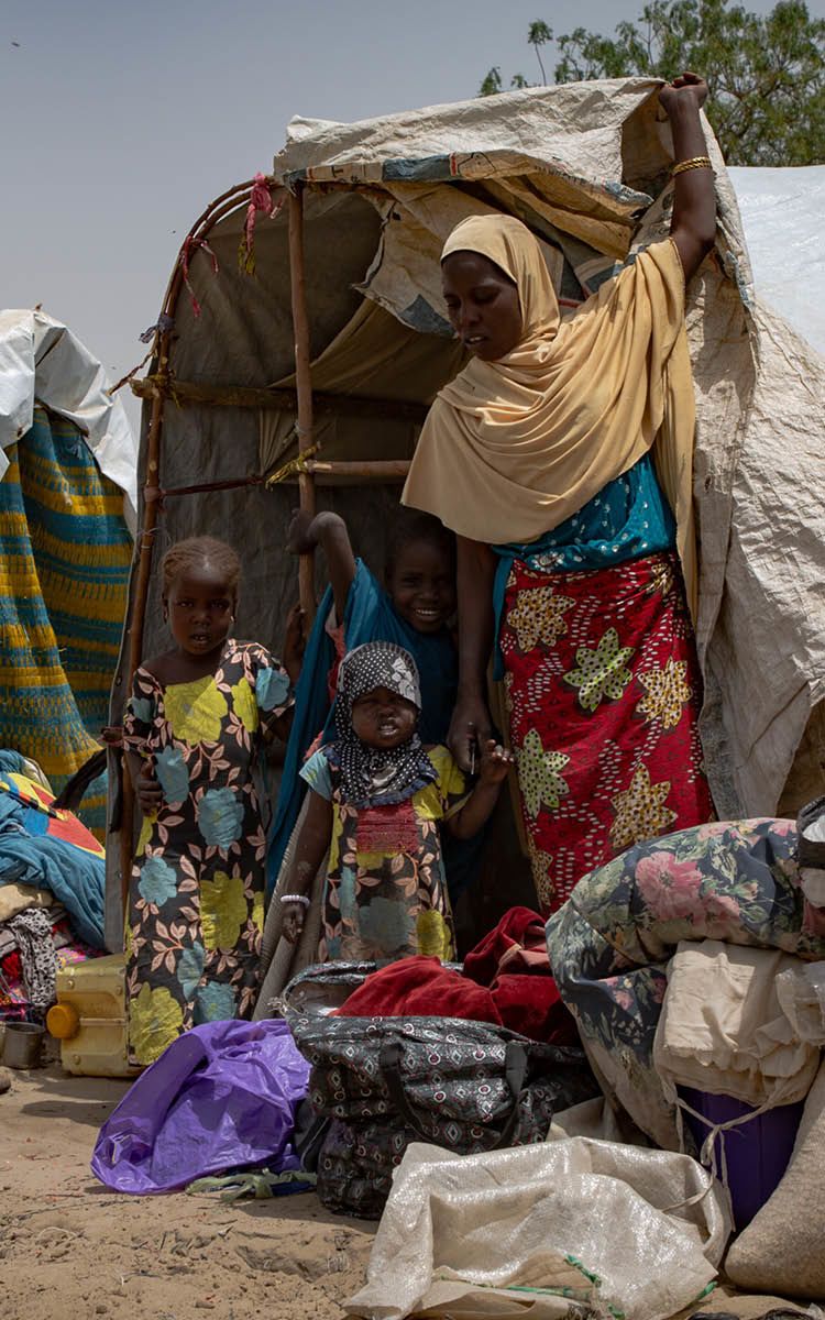 Kodo og barna hennes foran inngangen til sitt foreløpige hjem i Ngala-leiren som ligger i det nordøstlige Nigeria.