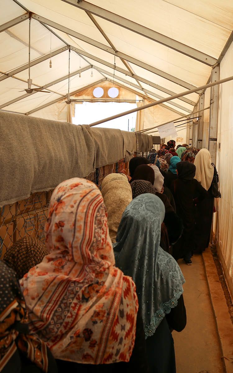 Kvinner står i kø for å få utdelt hjelp fra UNHCR.